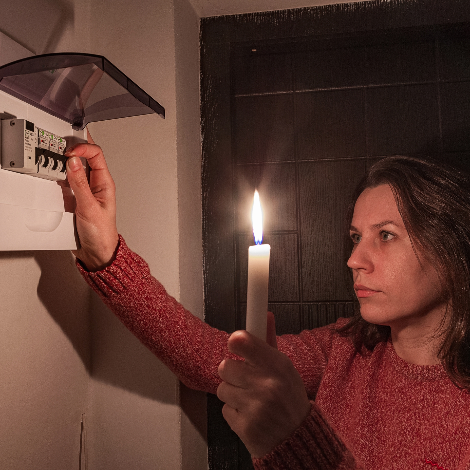 A woman turns on automatic fuses during a electric outage.