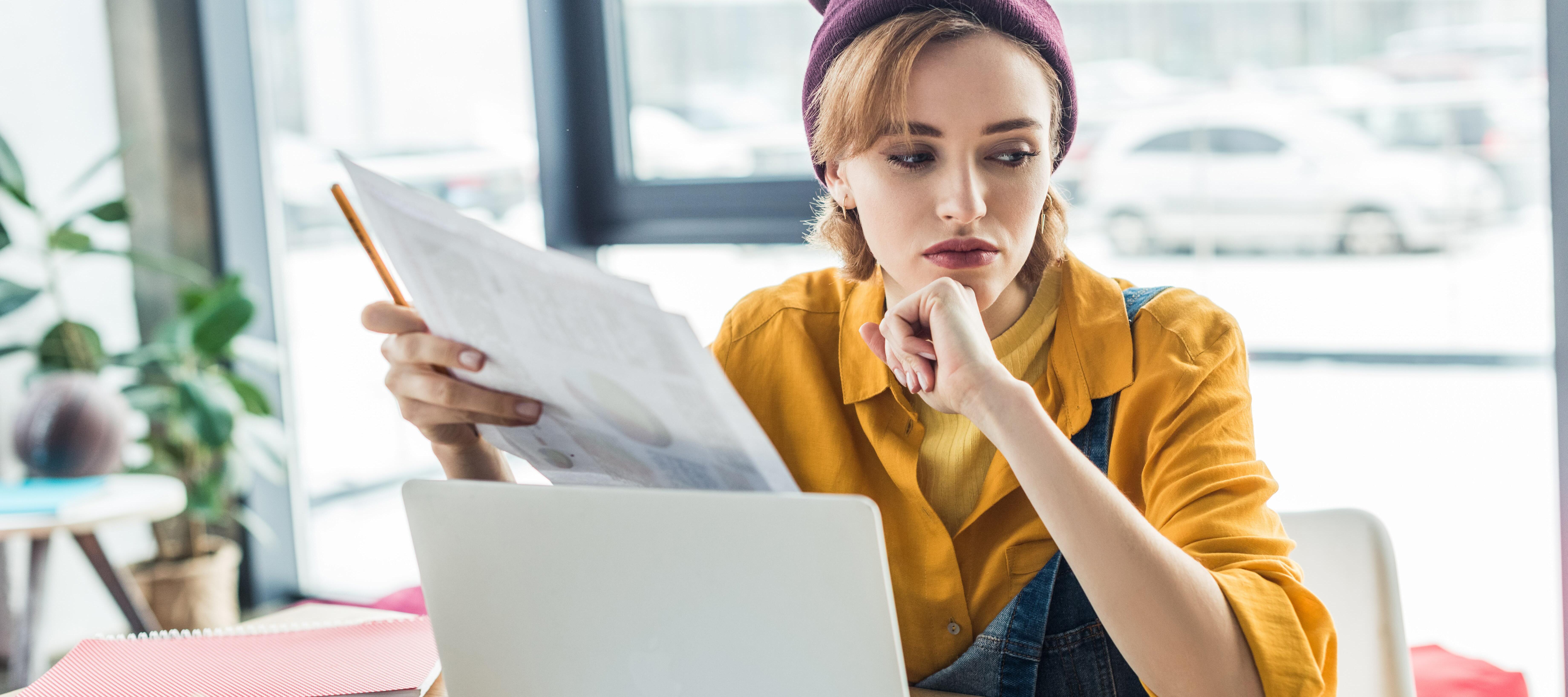 Pensive young woman at computer desk