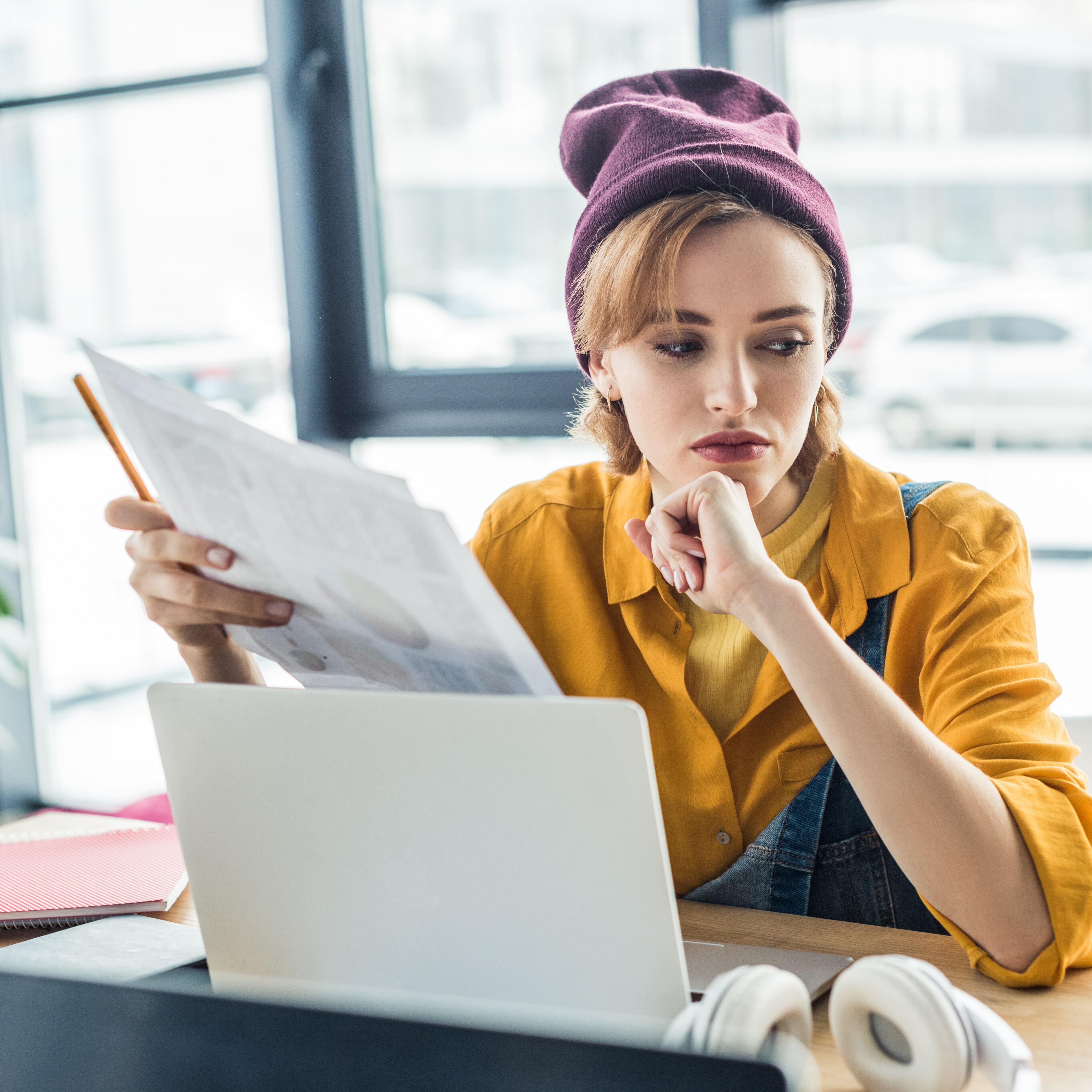 Pensive young woman at computer desk