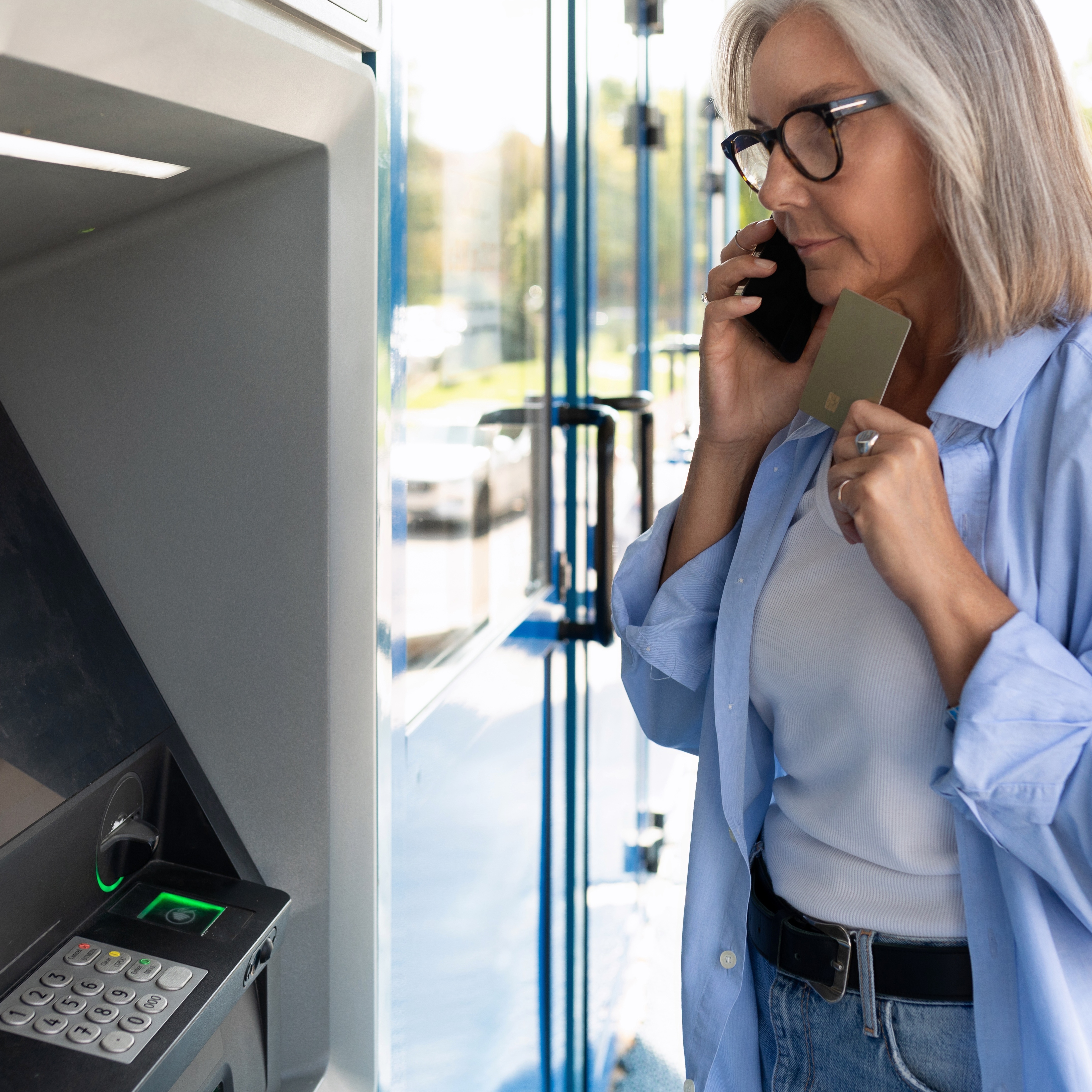 A woman seen talking on the phone in front of an ATM as online romance scammers continue to fool victims, with $298 million in losses reported in 2025.