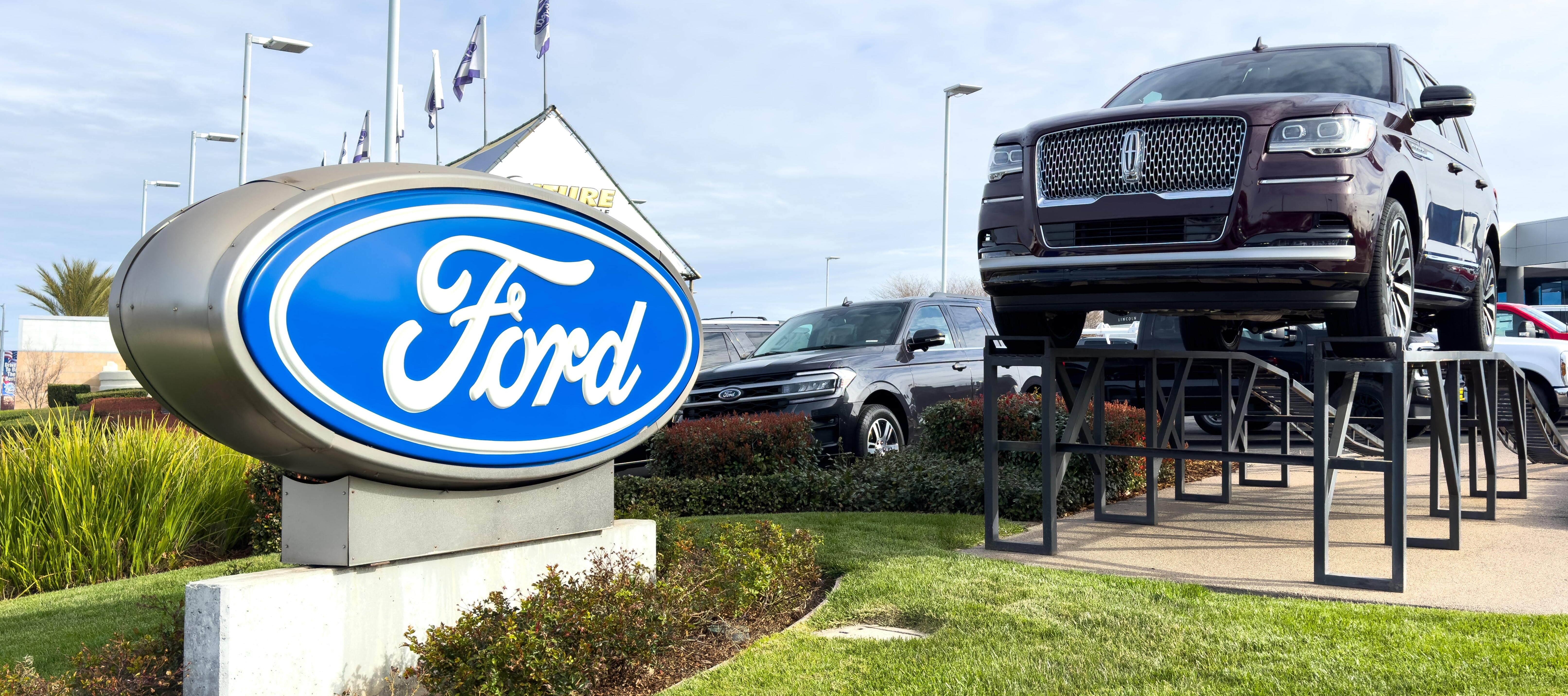 A Ford truck is displayed in front of a Ford dealership.