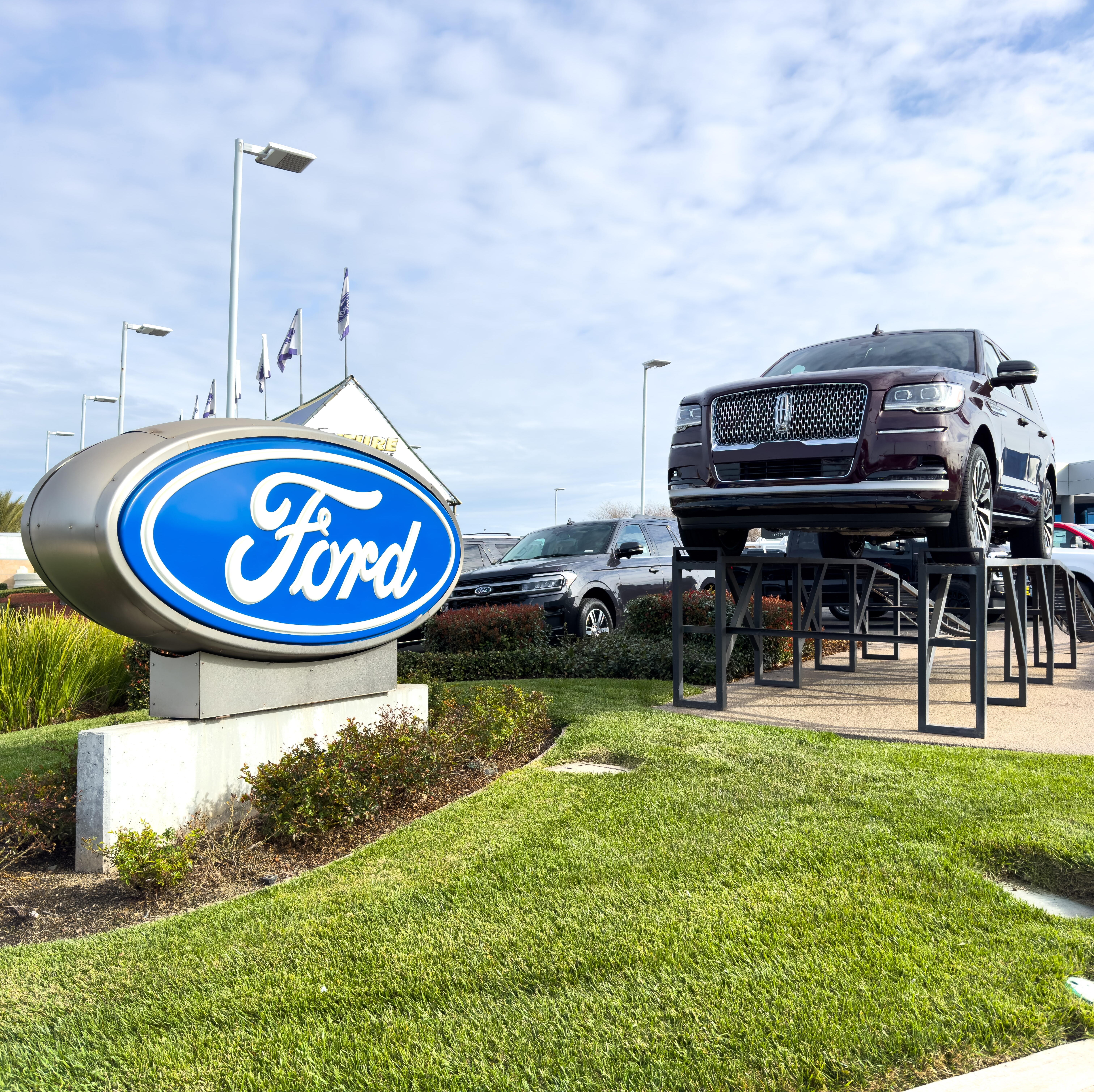 A Ford truck is displayed in front of a Ford dealership.