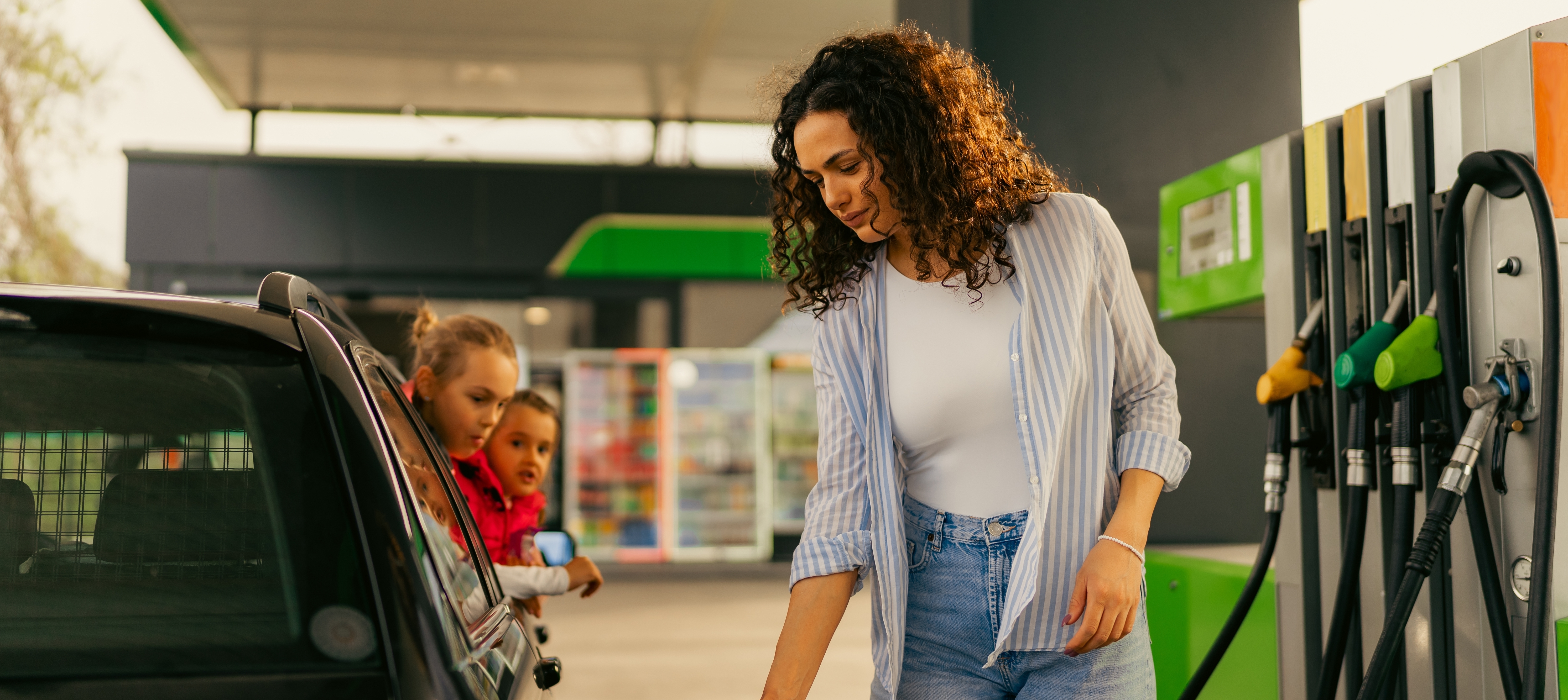 Photo of a woman filling her car with gas