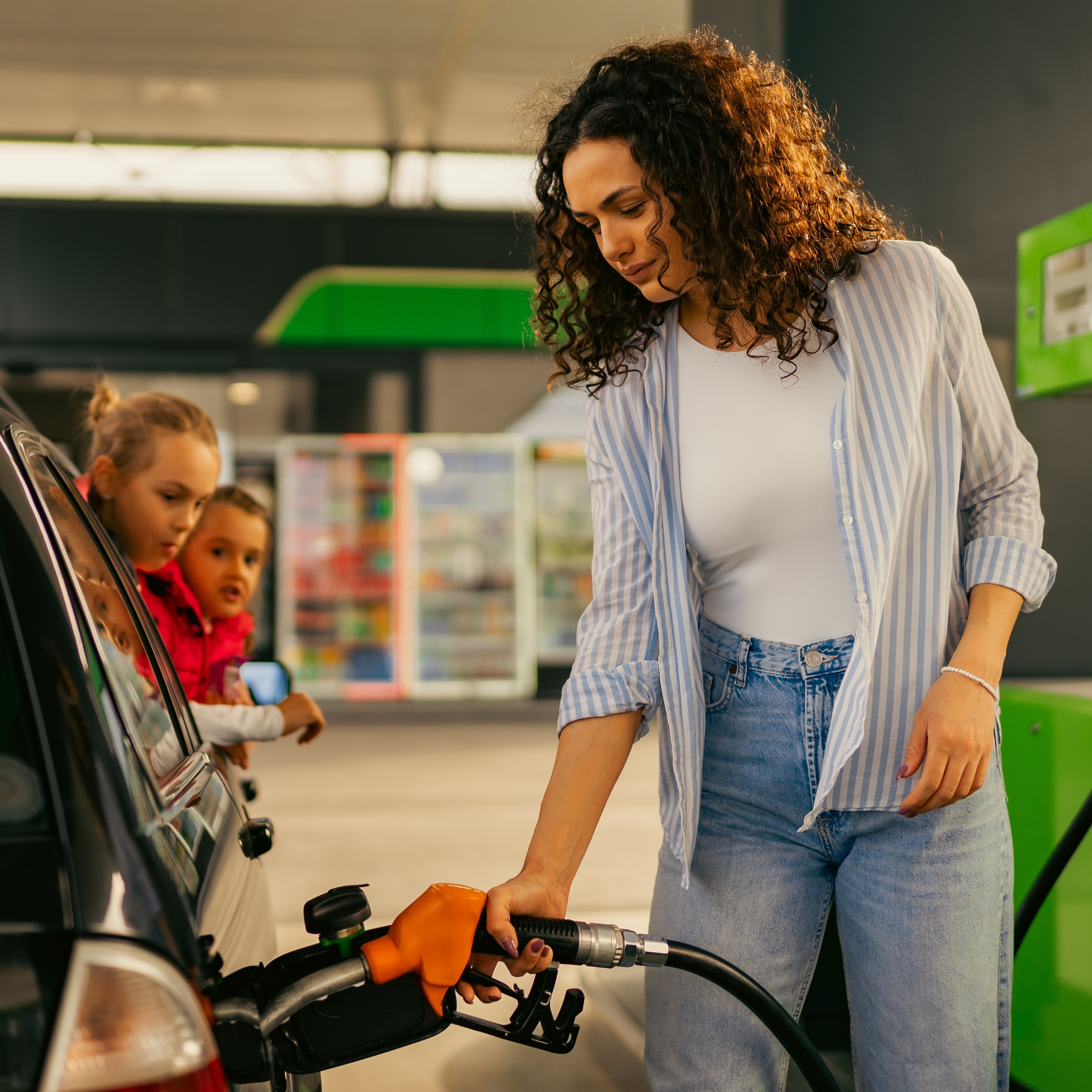 Photo of a woman filling her car with gas