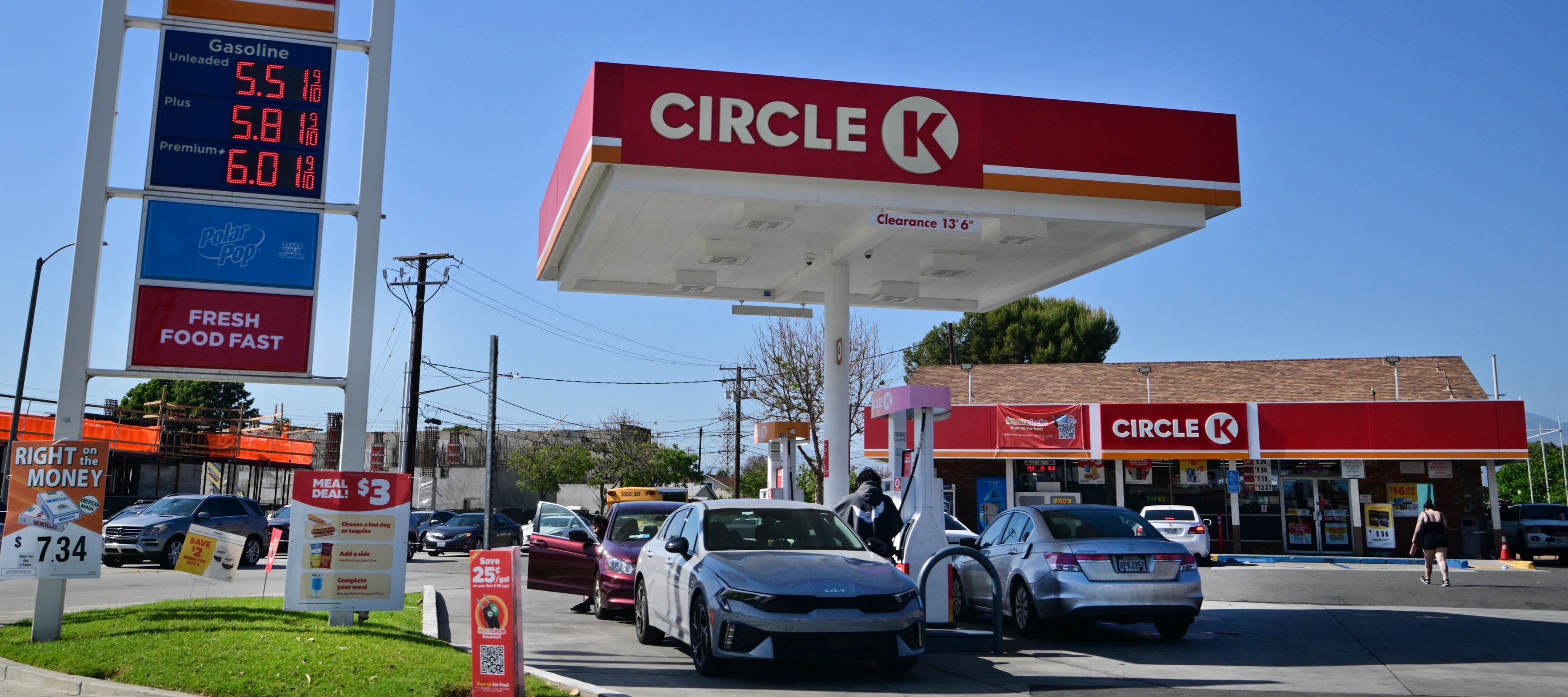Cars sit in a Circle K gas station with prices clearly visible