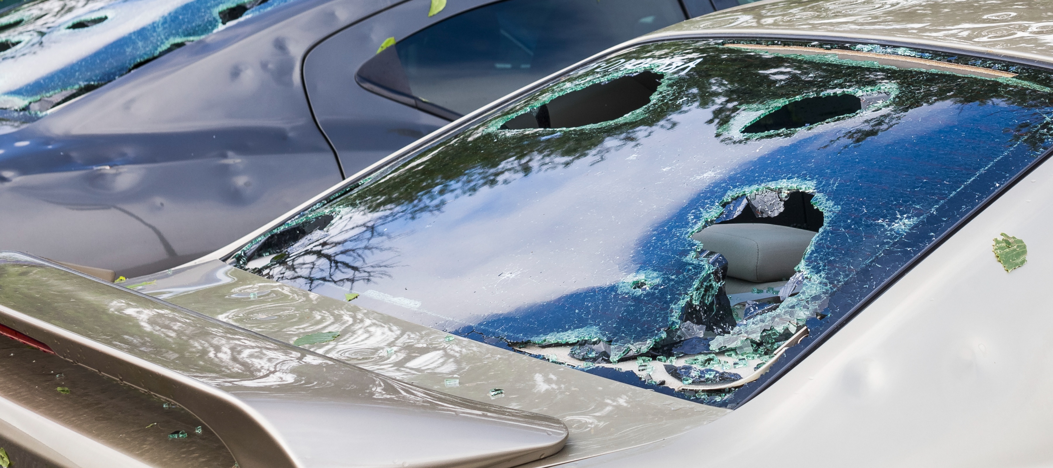Visible damage of a car from a hail storm shows giant holes in the windows