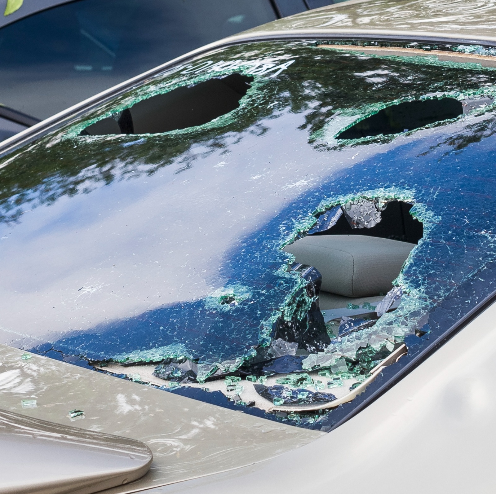 Visible damage of a car from a hail storm shows giant holes in the windows