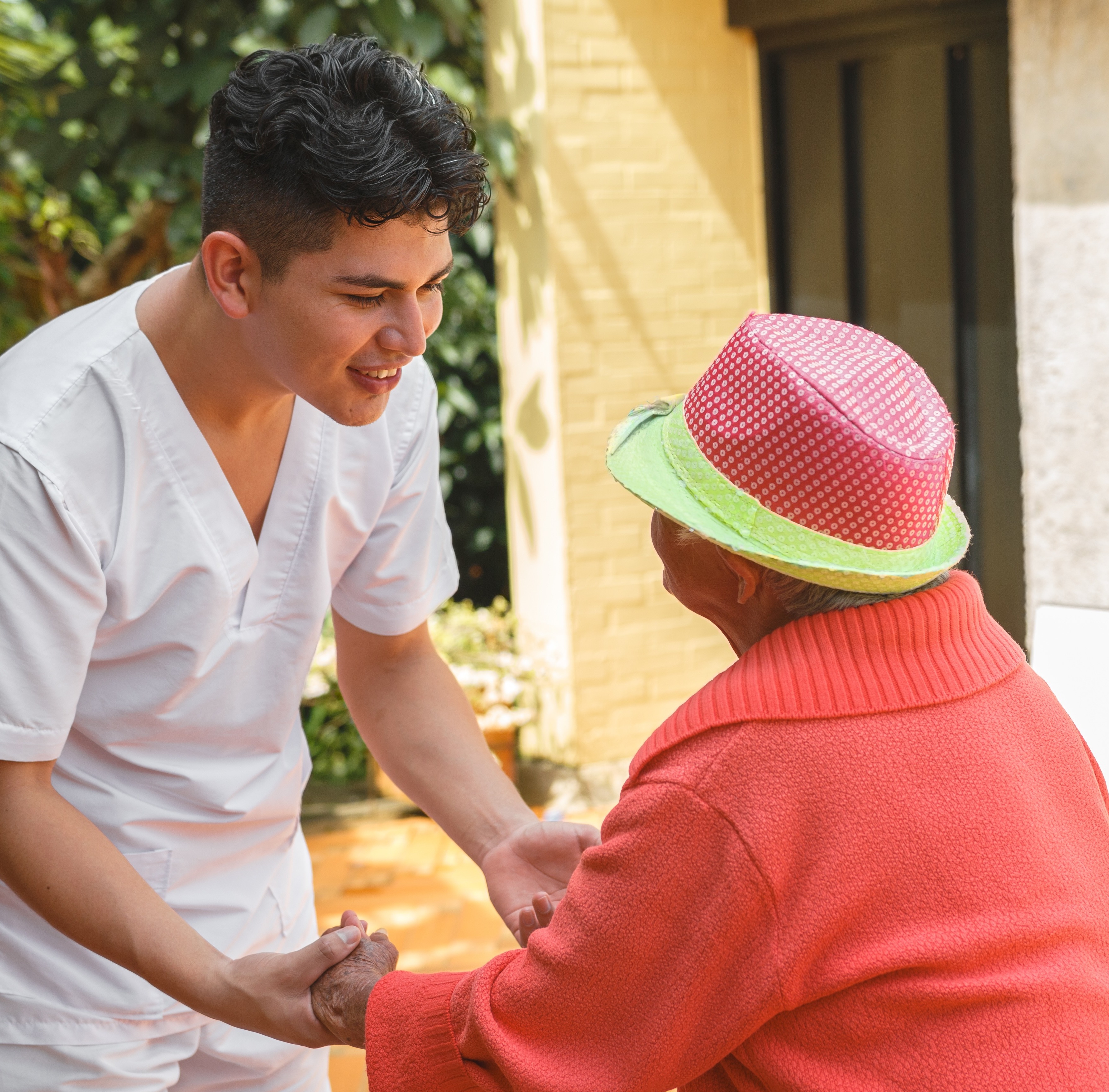 Young worker in nursing home helps senior woman