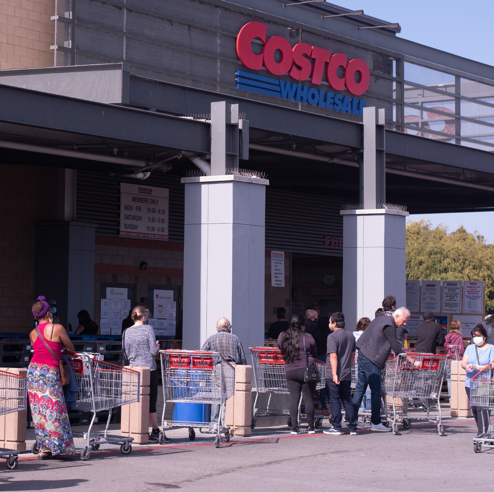 A line of people stand outside a Costco