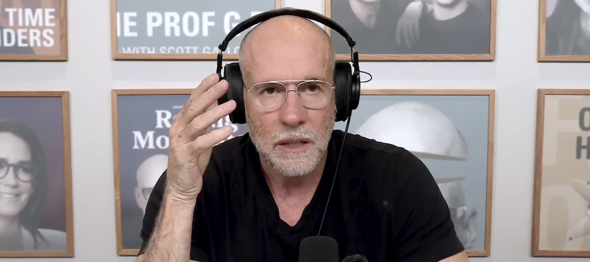 A close-up of Scott Galloway talking on his podcast about the transition of wealth while wearing a black t-shirt and over-ear headphones.