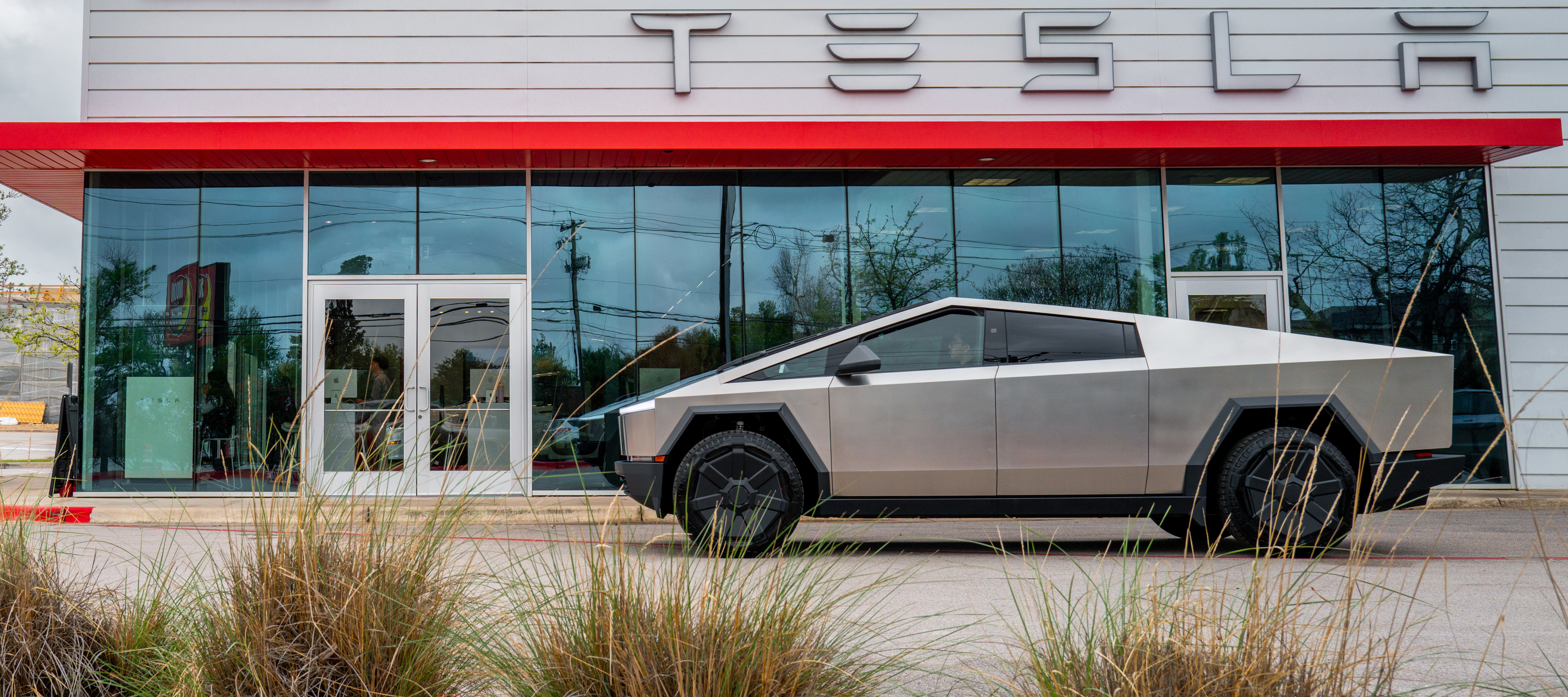 A Cybertruck is captured outside of a Tesla dealership.