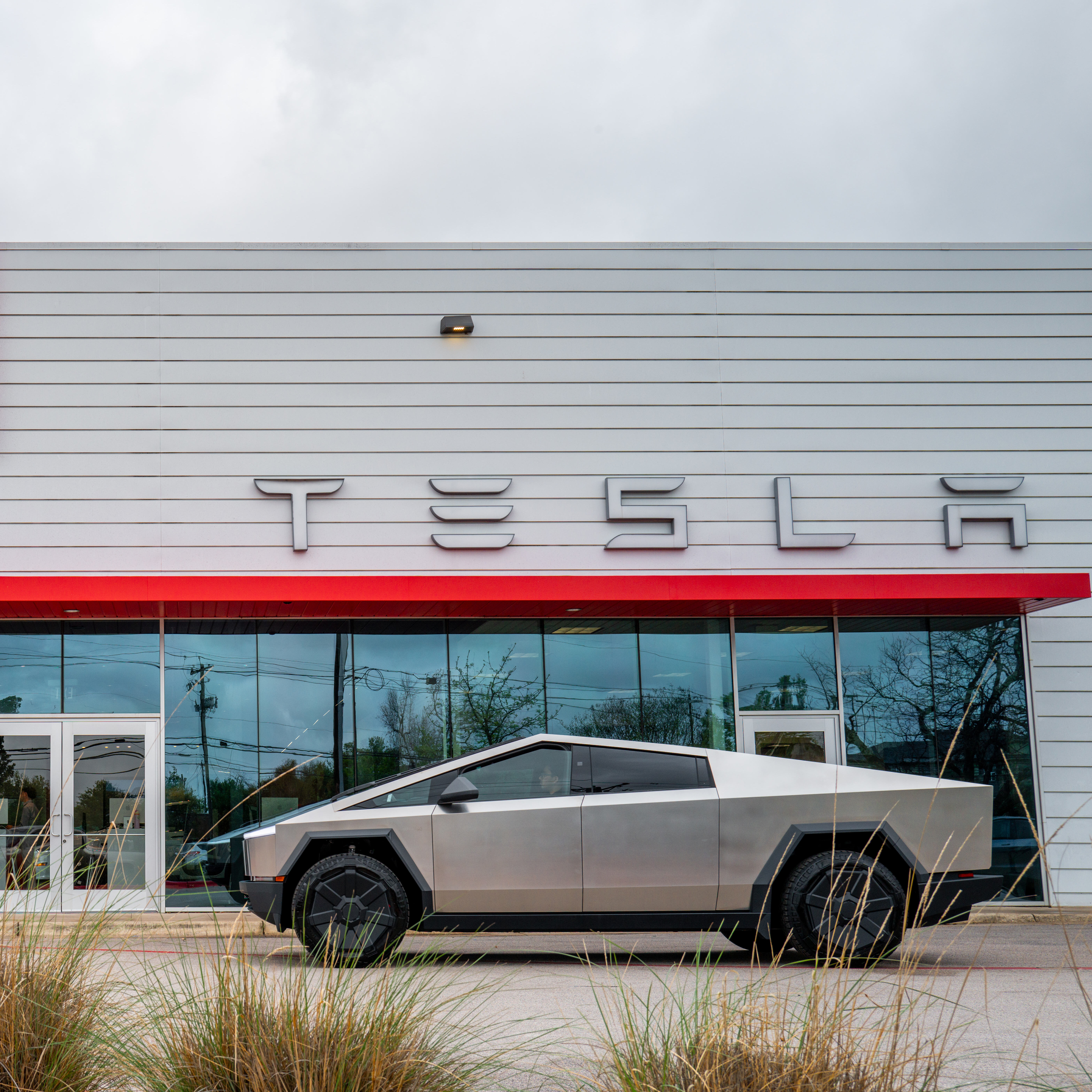 A Cybertruck is captured outside of a Tesla dealership.