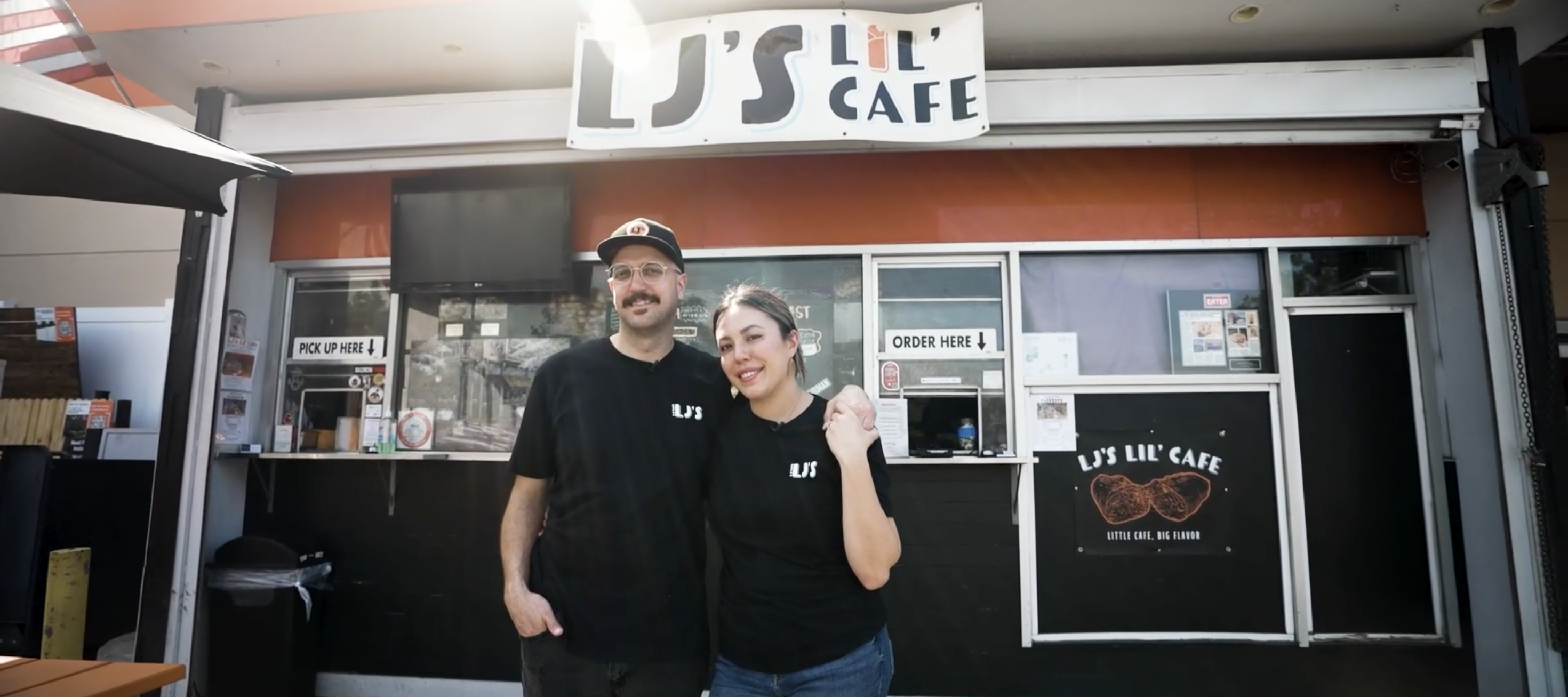 The owners of LJ’s Lil’ Cafe stand outside their flagship restaurant.