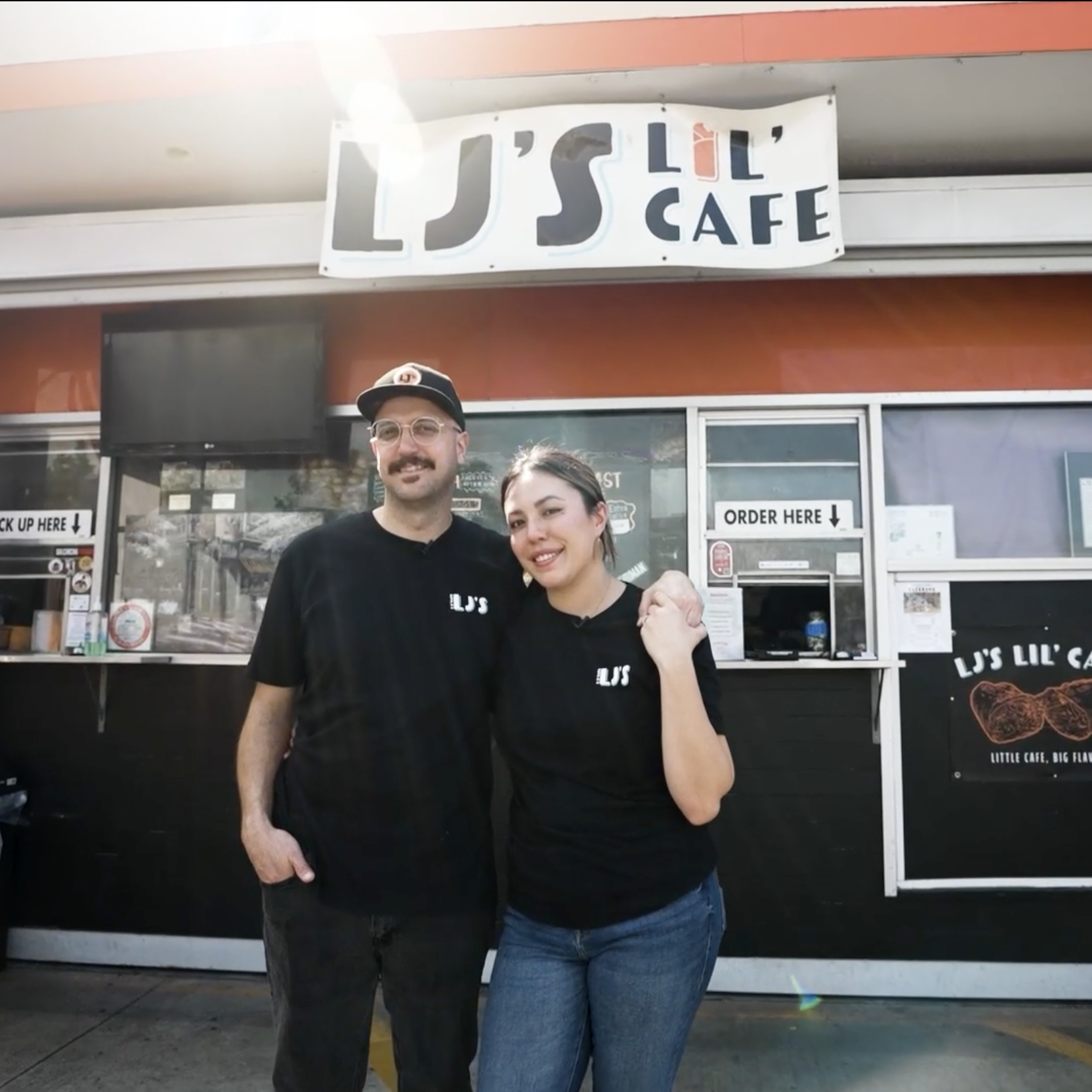 The owners of LJ’s Lil’ Cafe stand outside their flagship restaurant.