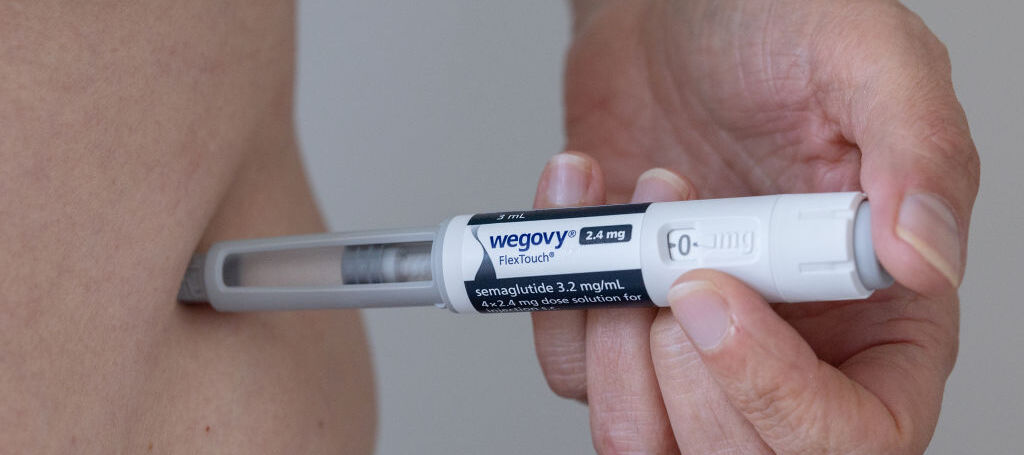 A photo of a person administering a Wegovy injection