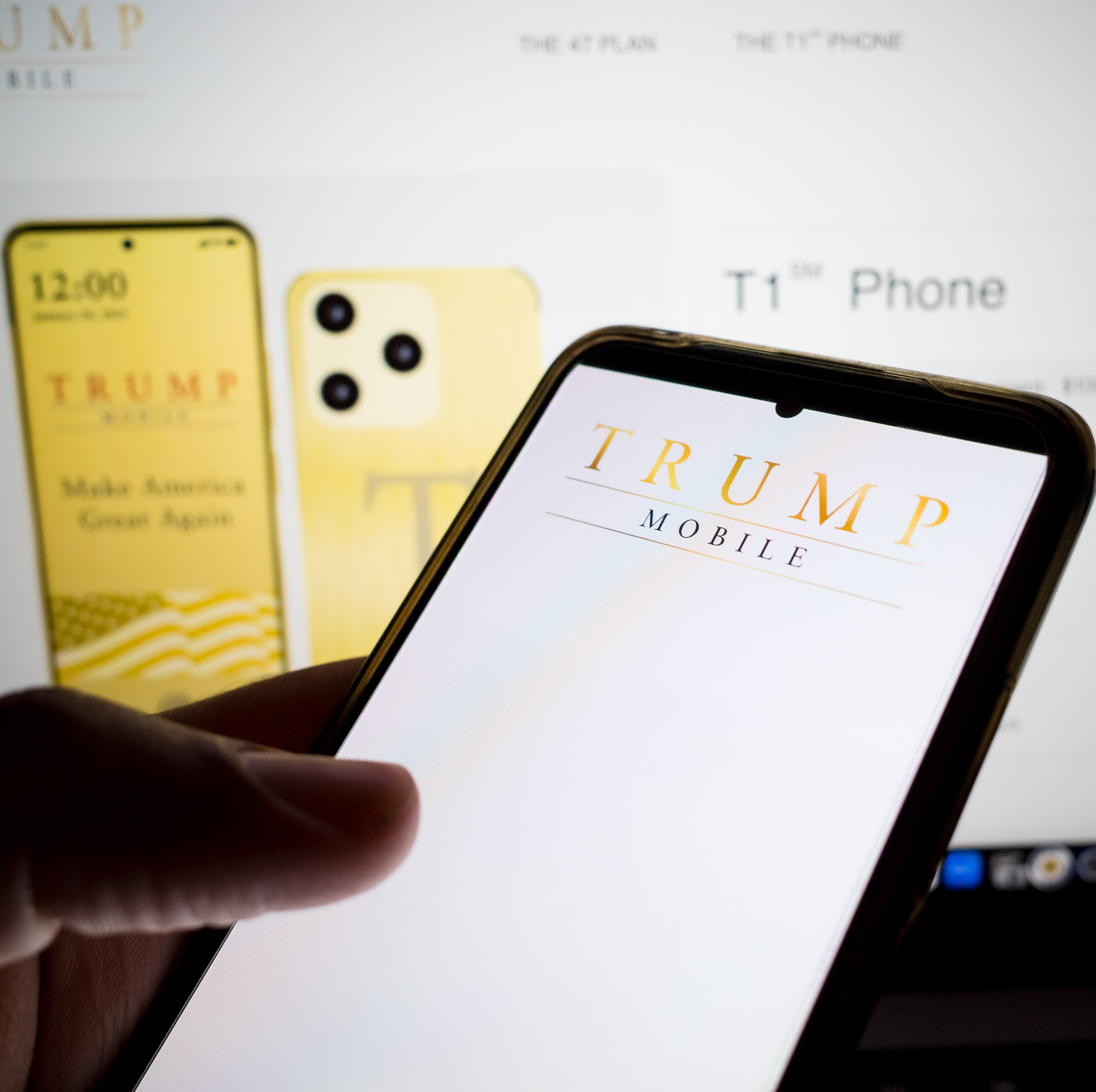 Person on Trump Mobile website on a smartphone with T1 phone preorder page up in the background.