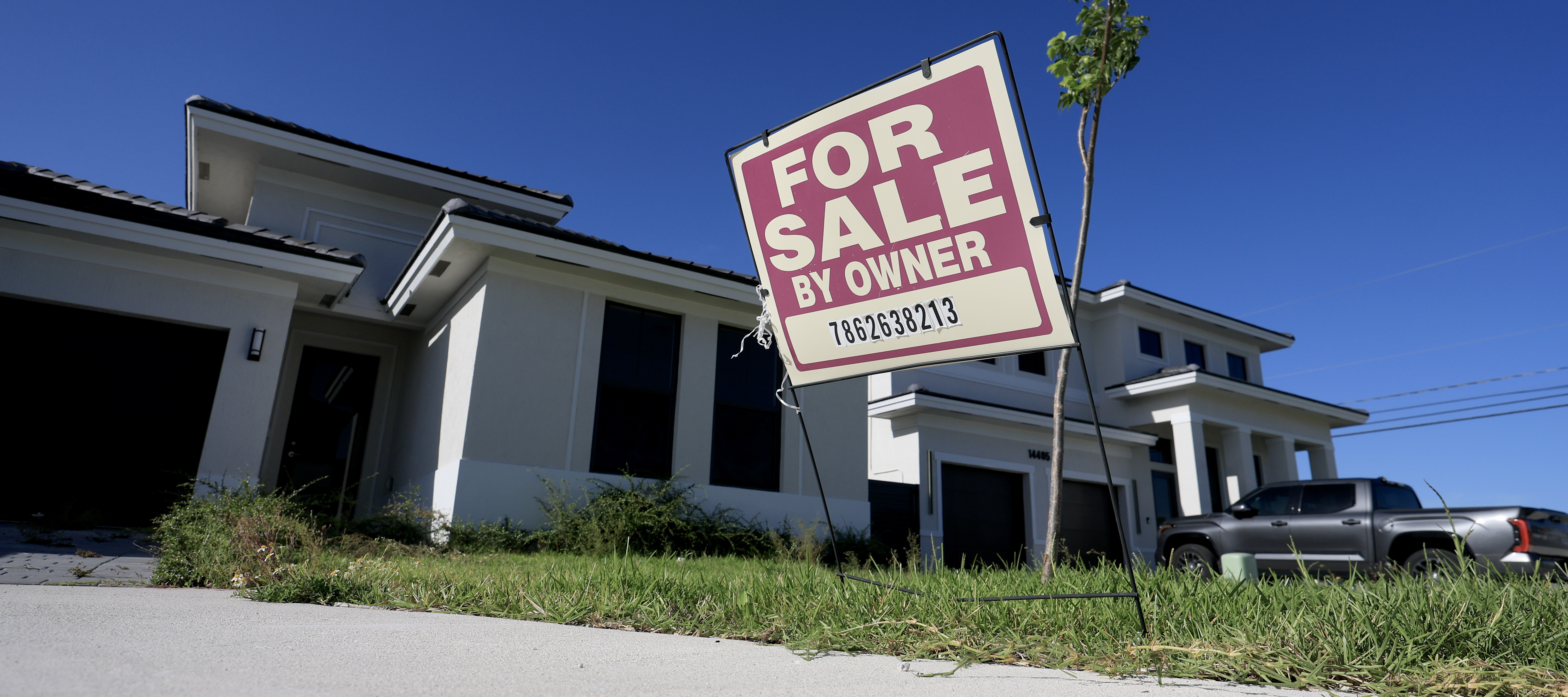 A 'for sale' sign sits in front of a single family home in Miami, Florida.