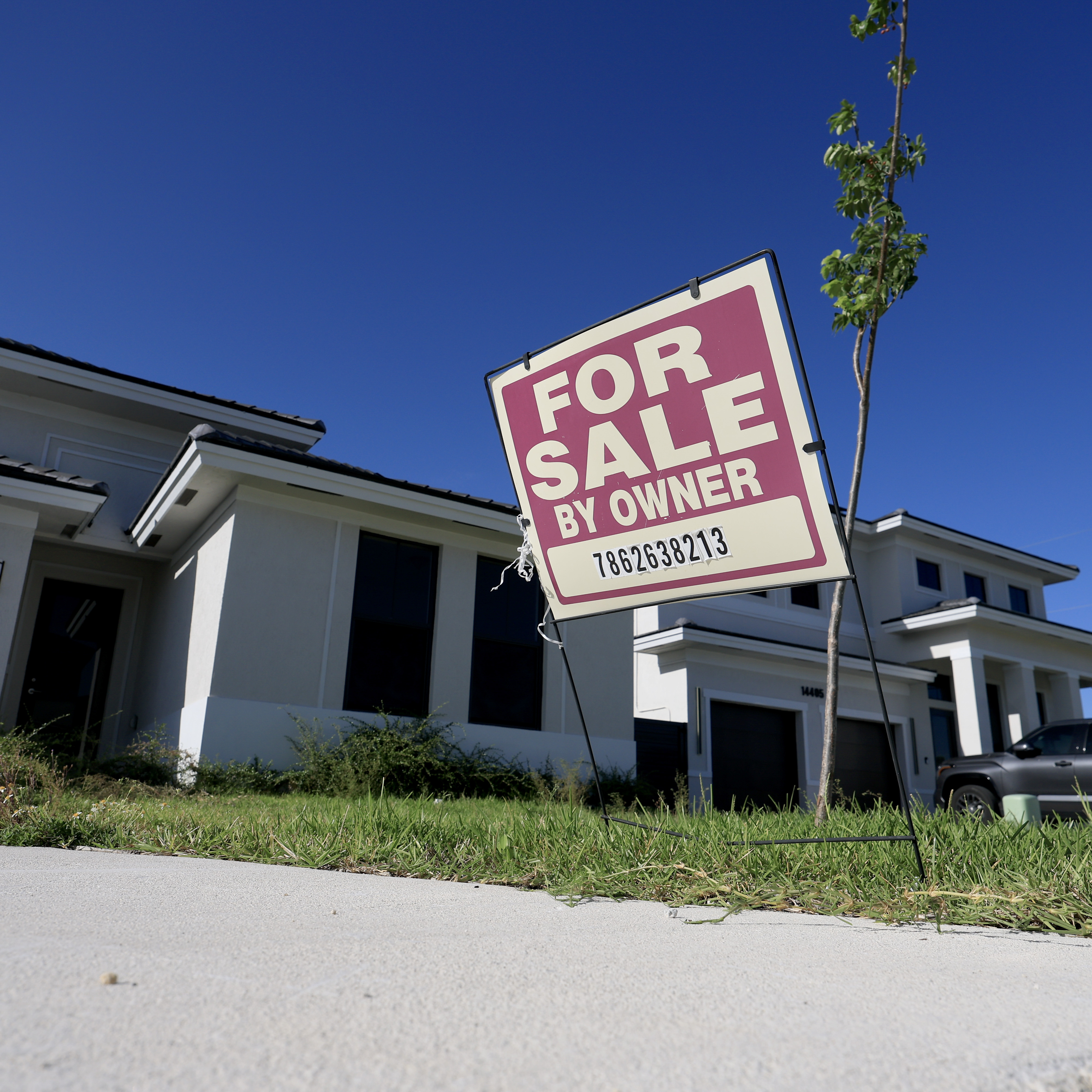 A 'for sale' sign sits in front of a single family home in Miami, Florida.