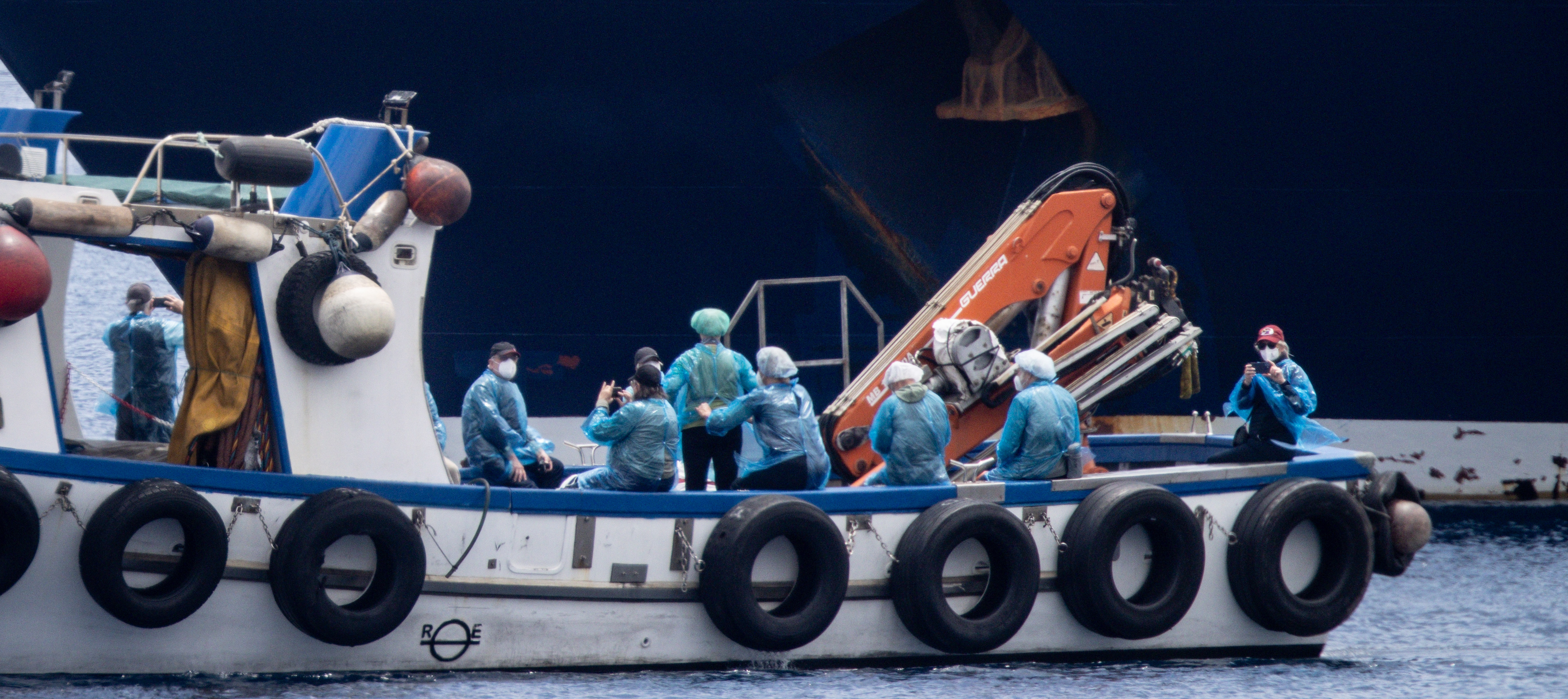 Passengers are evacuated by small boat from the MV Hondius.
