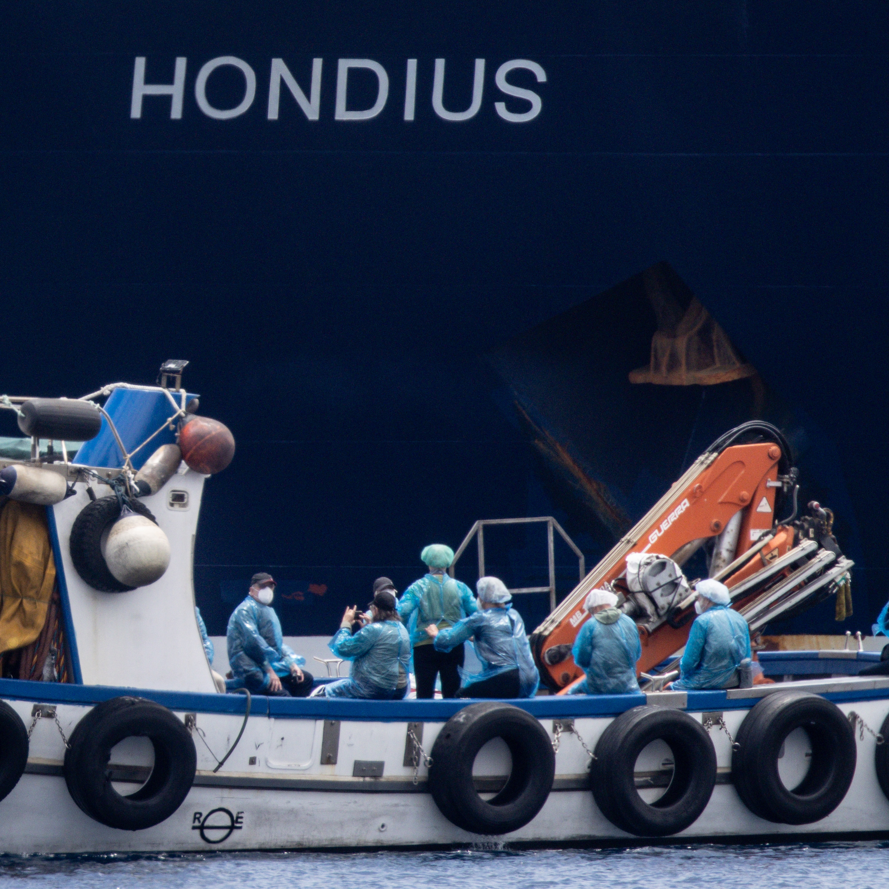 Passengers are evacuated by small boat from the MV Hondius.