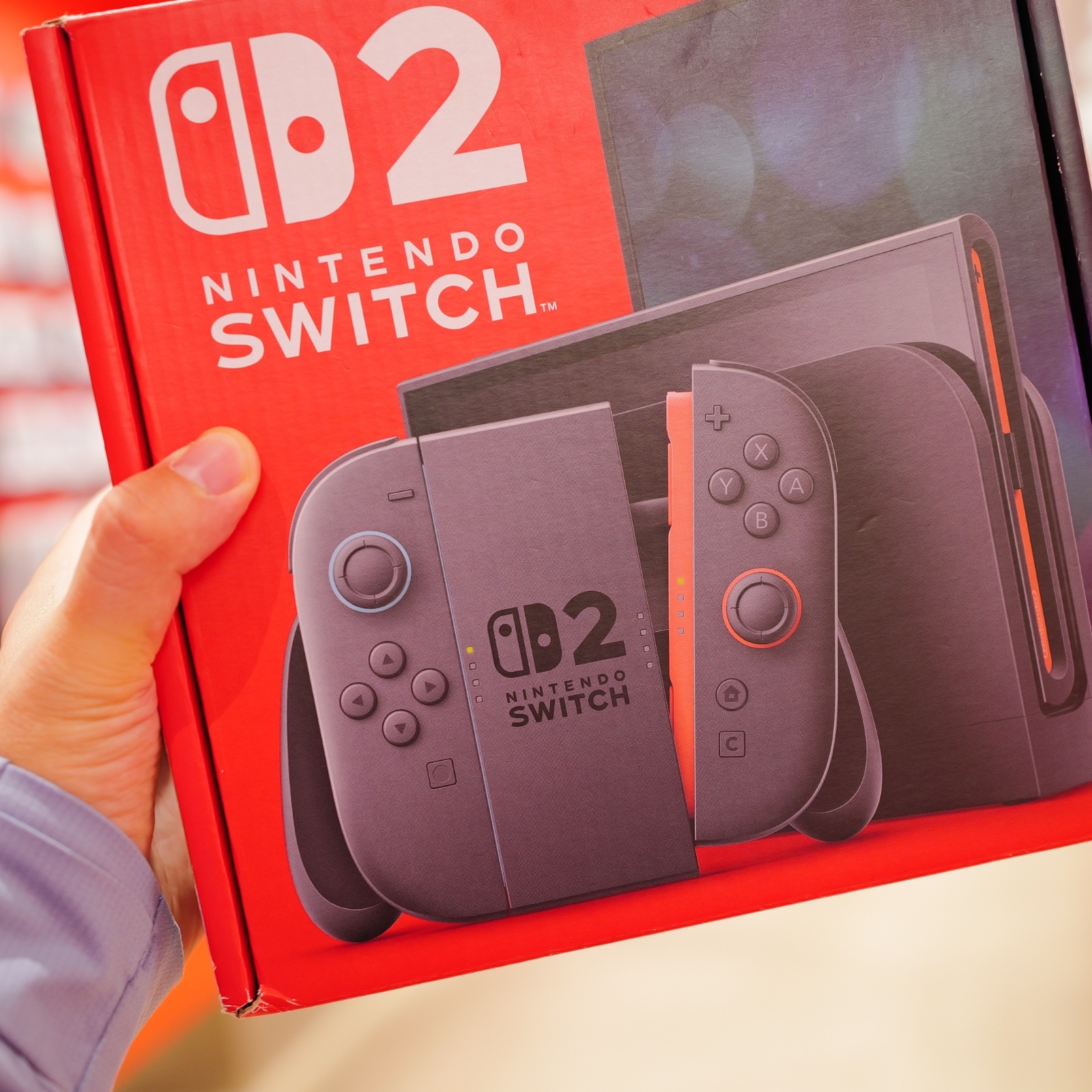 A customer holds a Nintendo Switch 2 box.