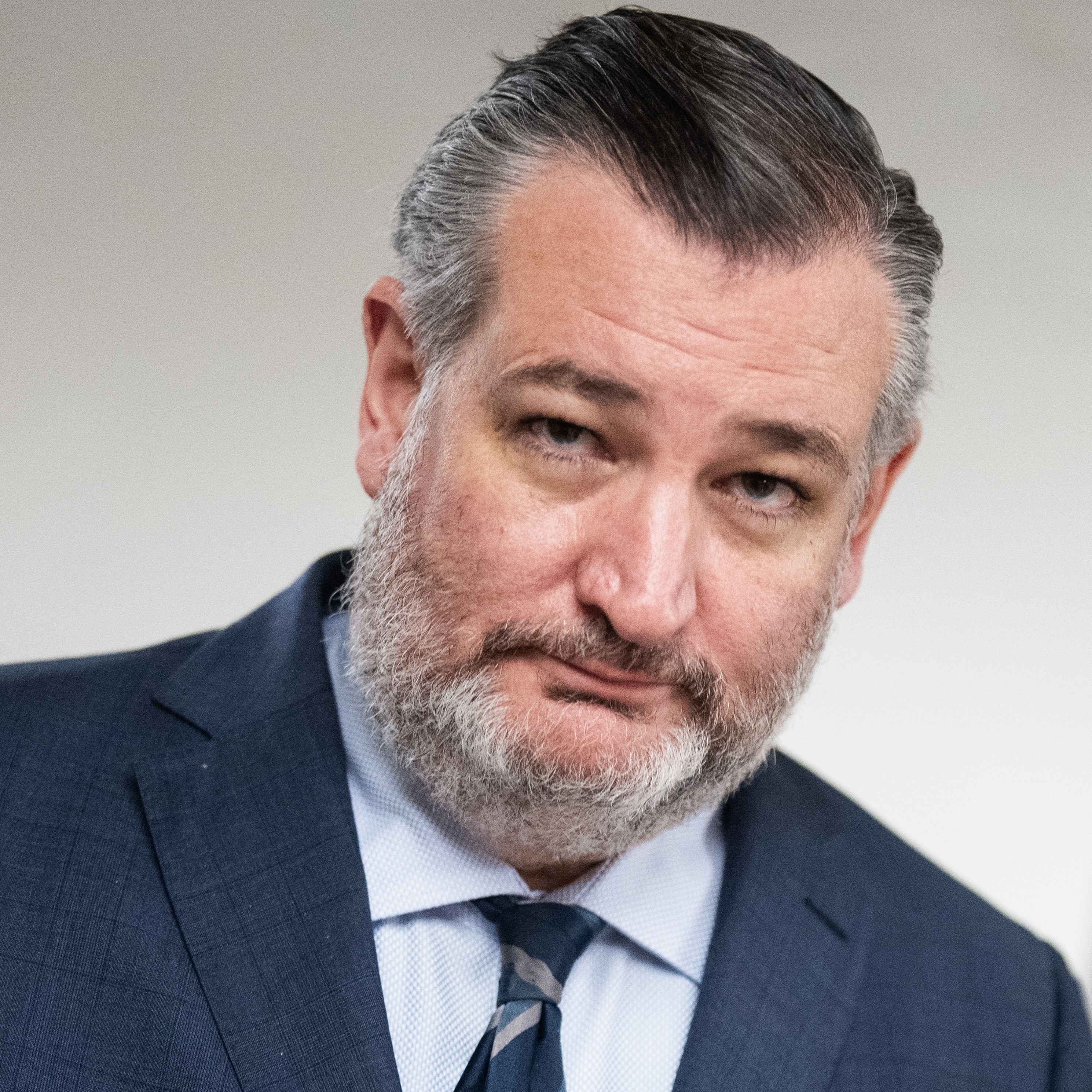 Ted Cruz looks at the camera in a dark blue suit and tie.