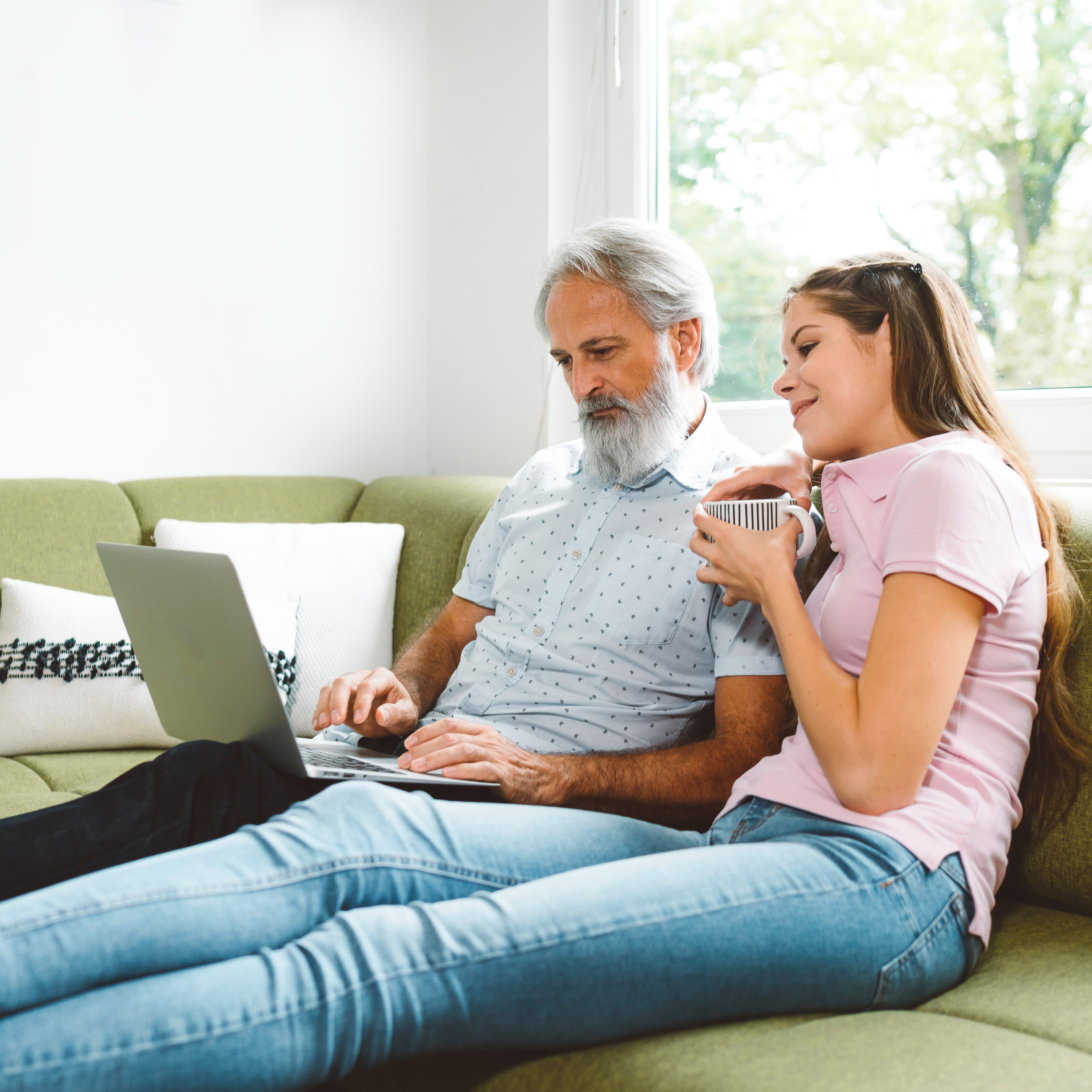 Senior man talking with his daughter on the couch
