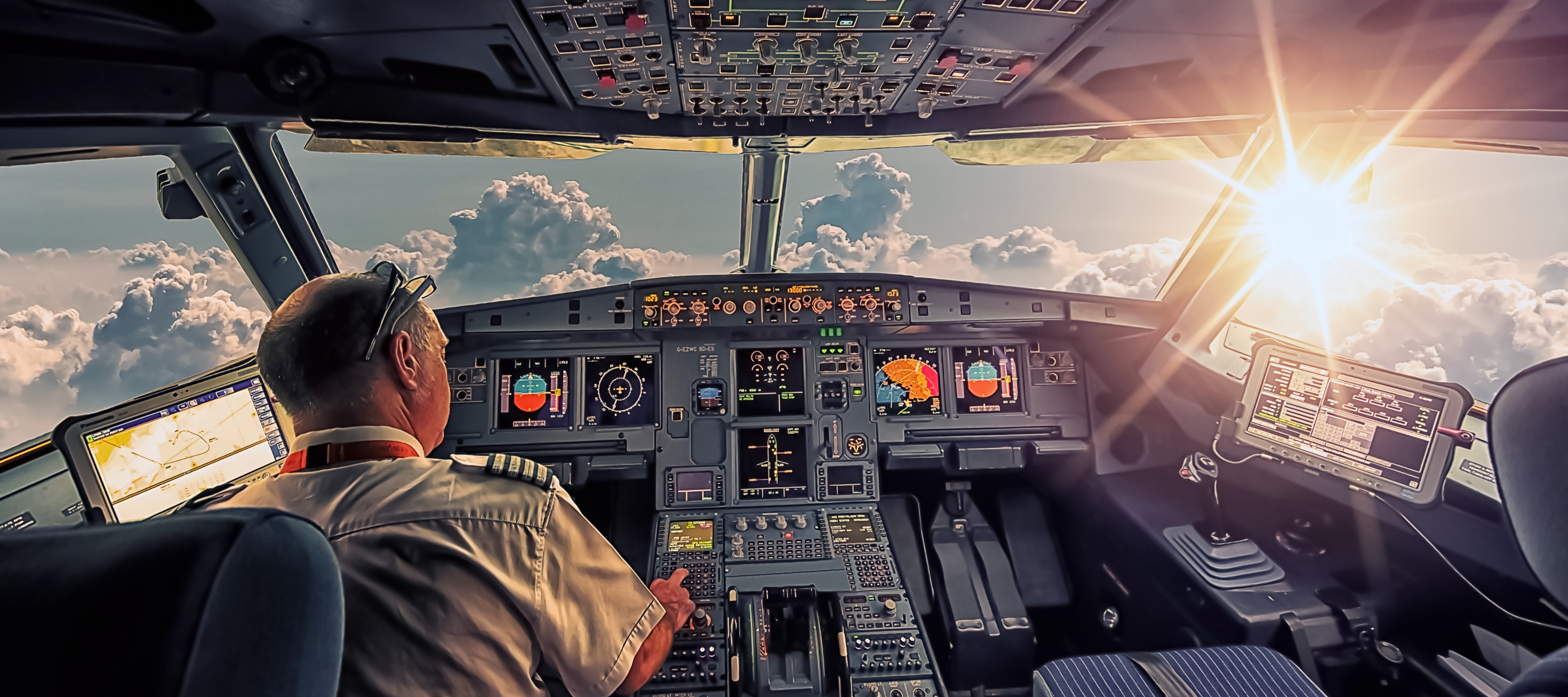 A pilot inside of an airplane flying towards the sun