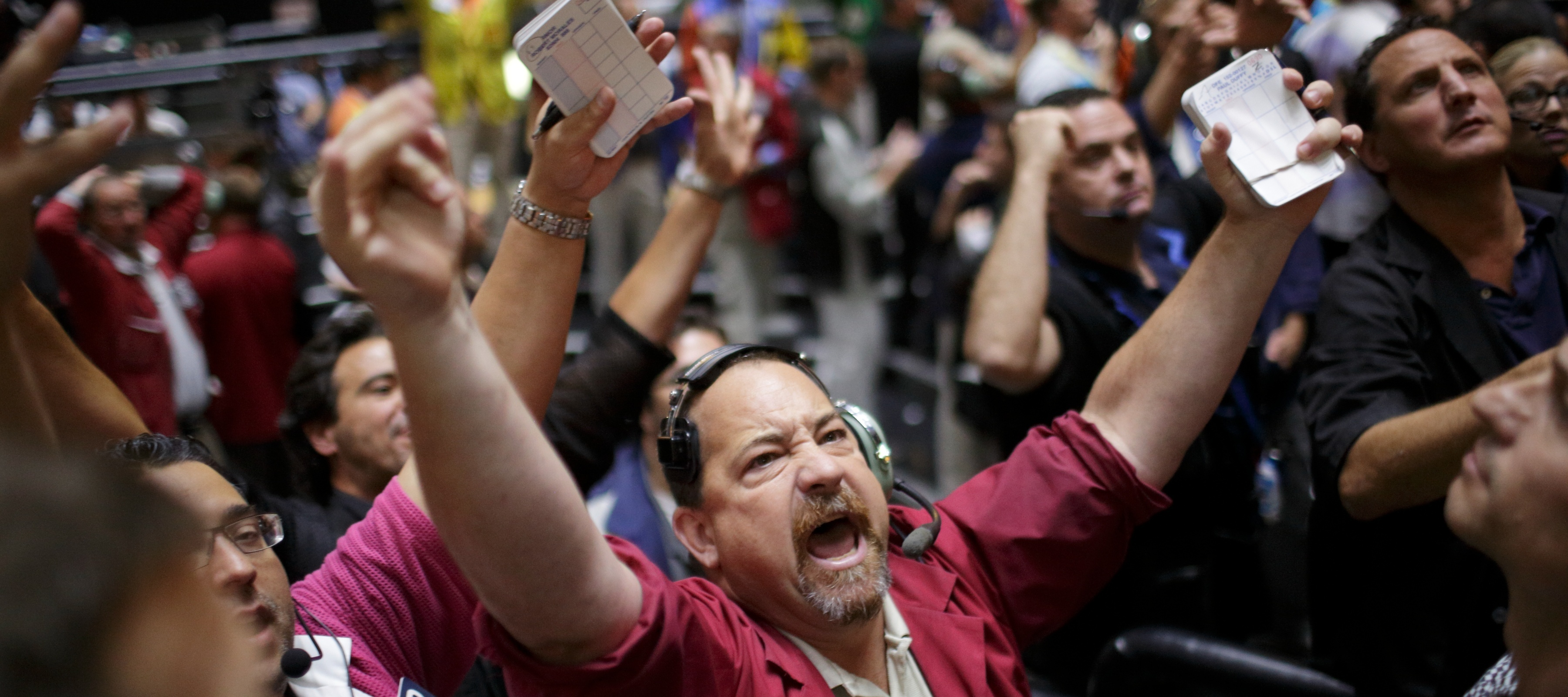 A trader throws up his hands and cheers