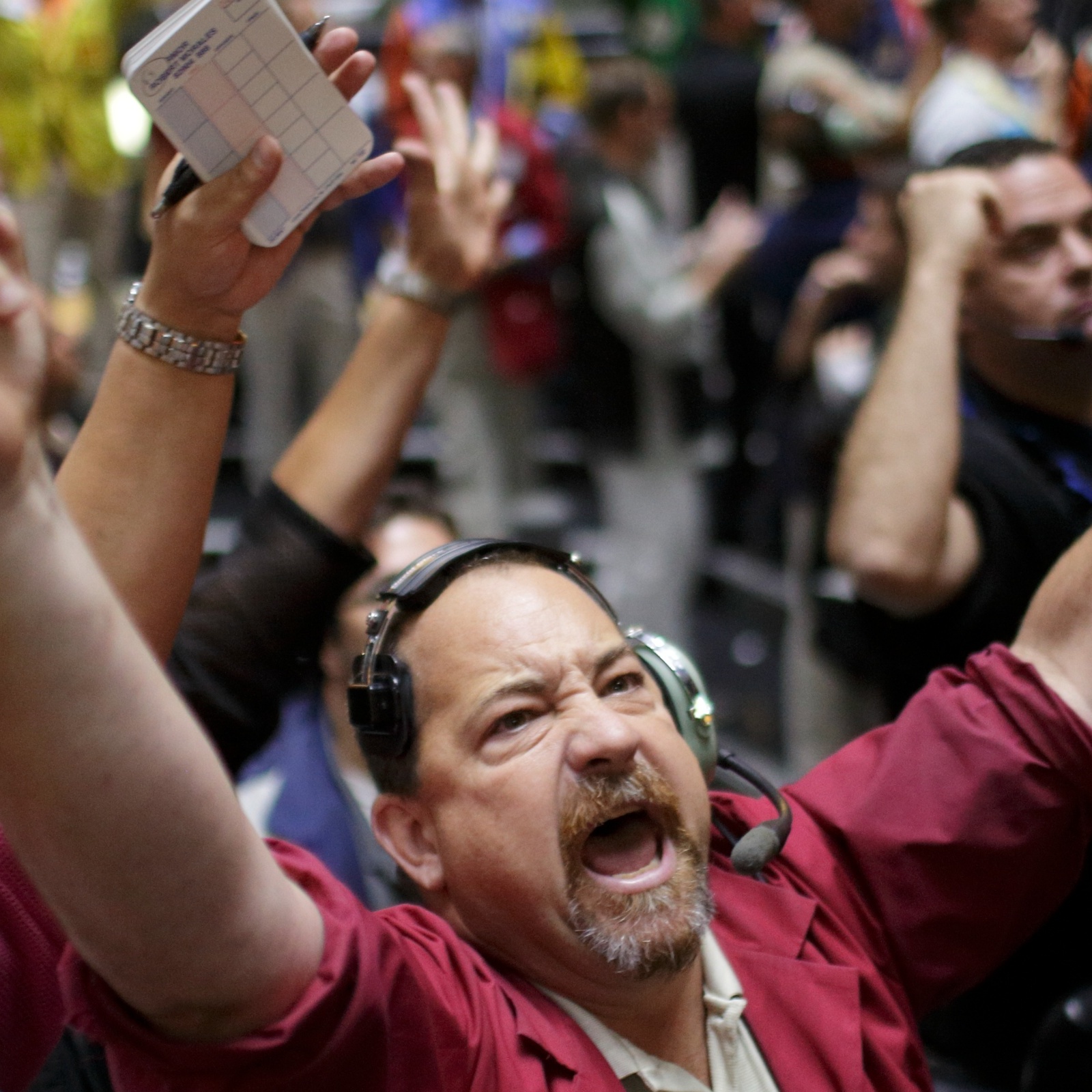 A trader throws up his hands and cheers