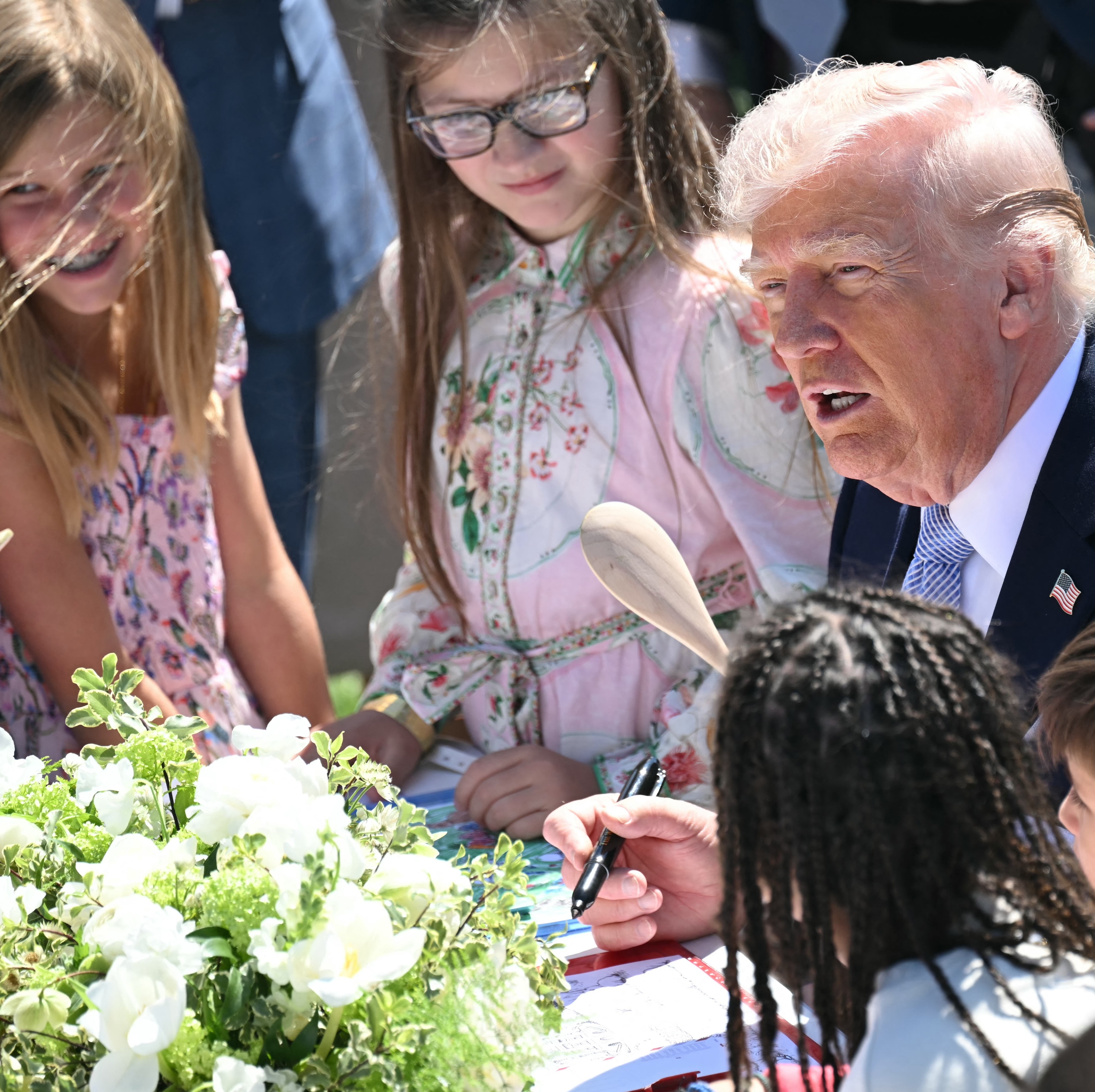 President Donald Trump participates in a coloring activity with children at the South Lawn at the White House.