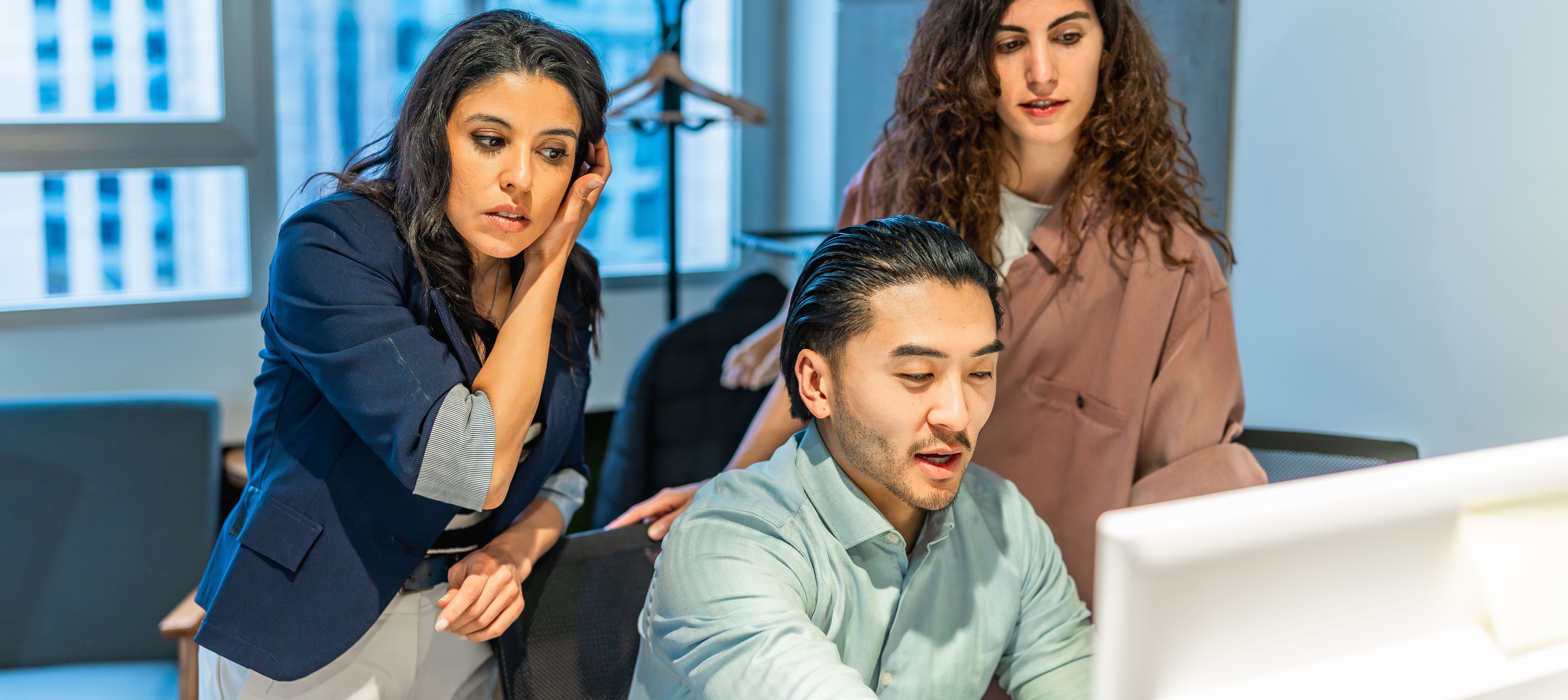 Tech workers surrounding computer