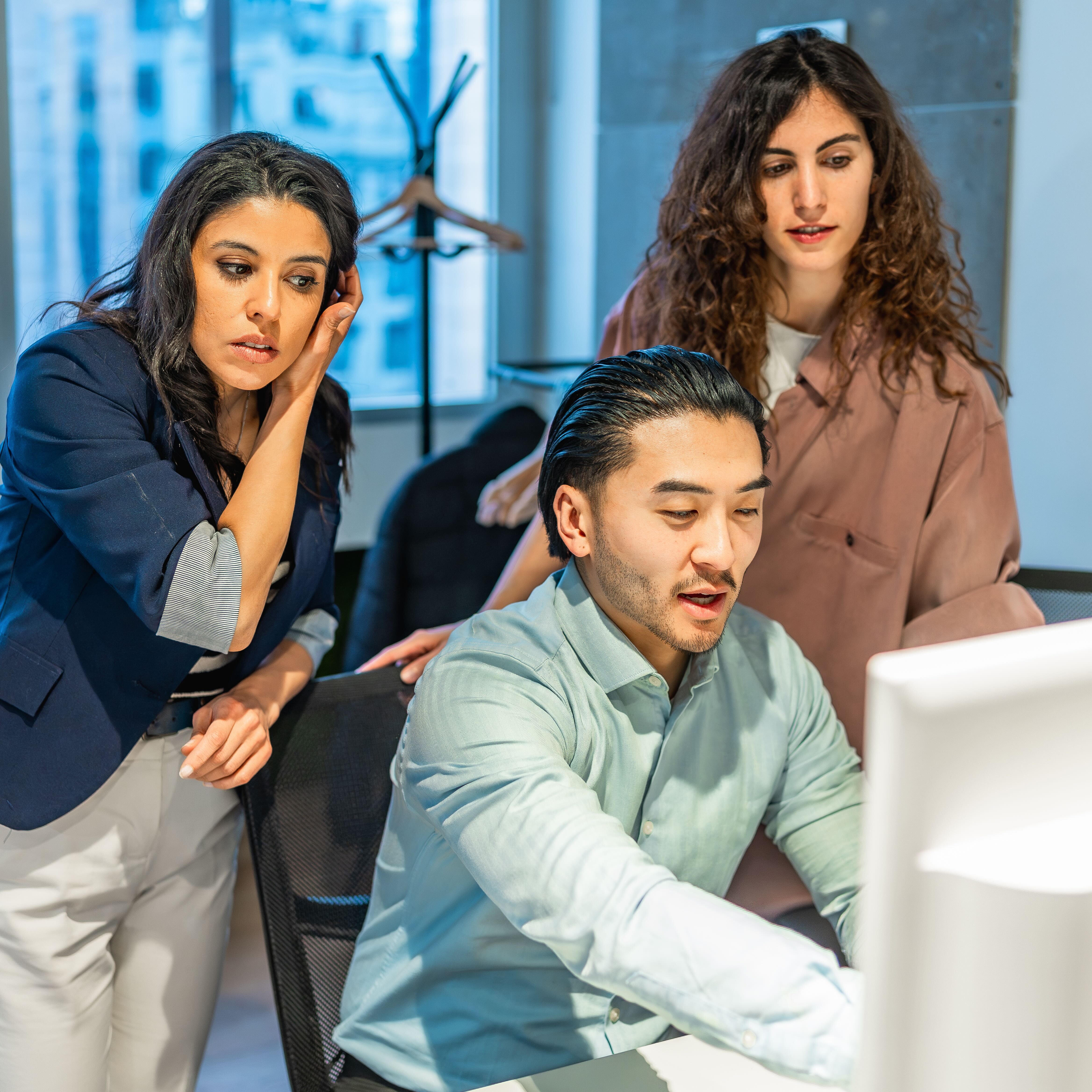 Tech workers surrounding computer