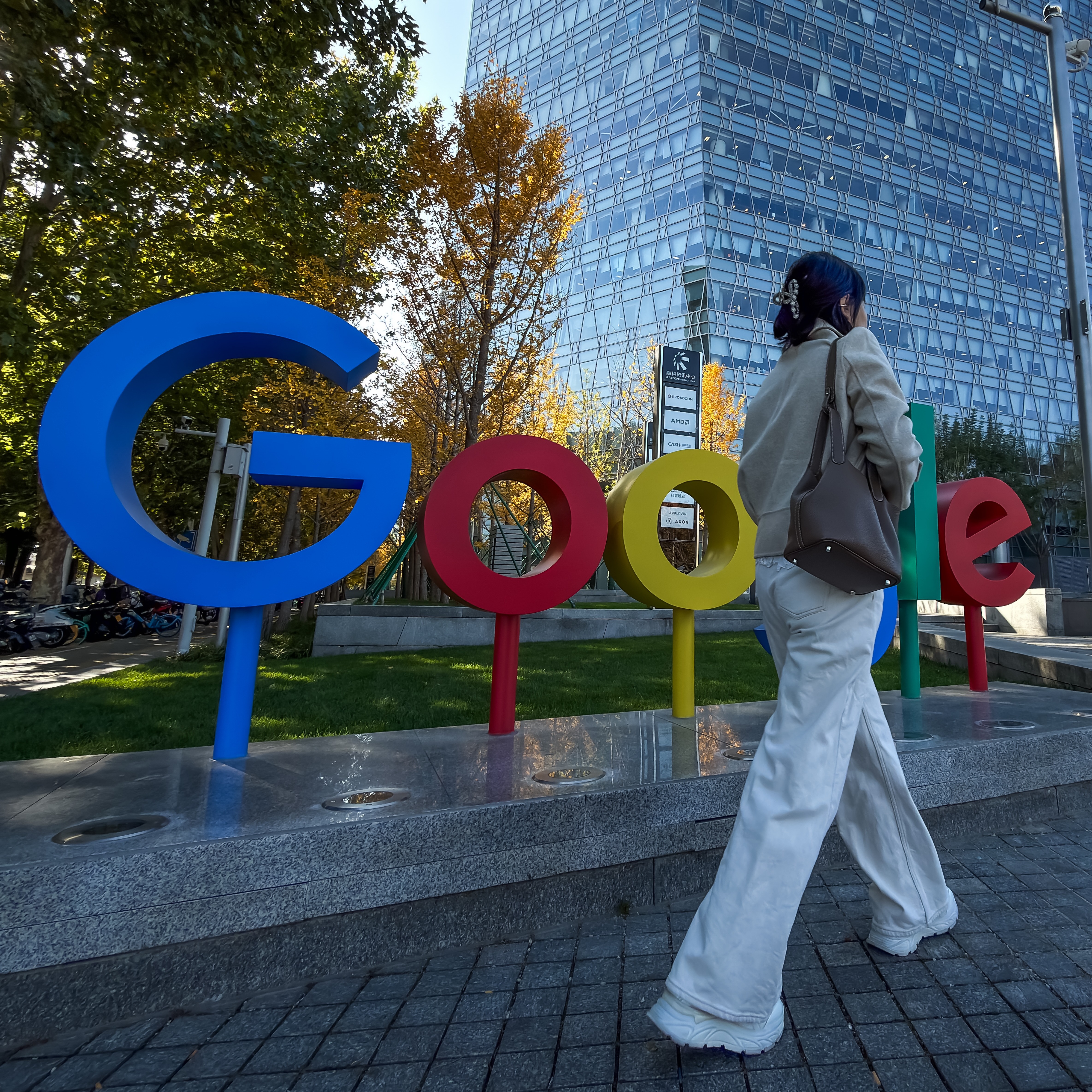 A pedestrian walks past the Google logo outside a commercial building that houses the company's Beijing office.