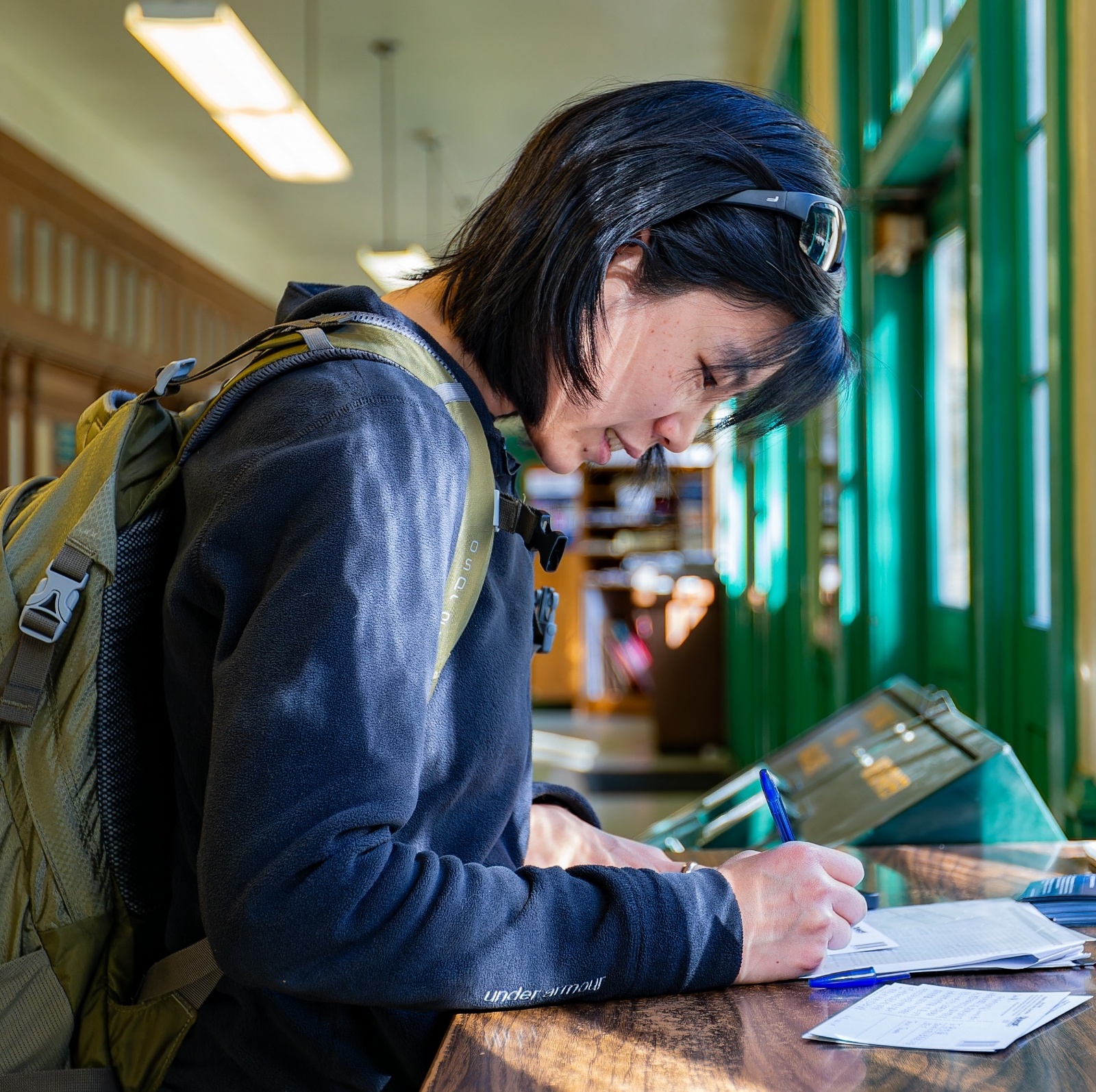 Interior view of the United States Postal Service at Yosemite as a woman fills out a form.