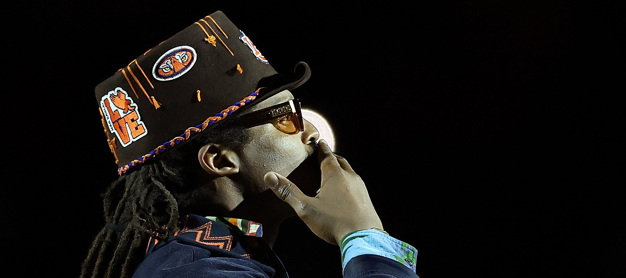 Cam Newton holds his hand over his mouth in quiet contemplation.