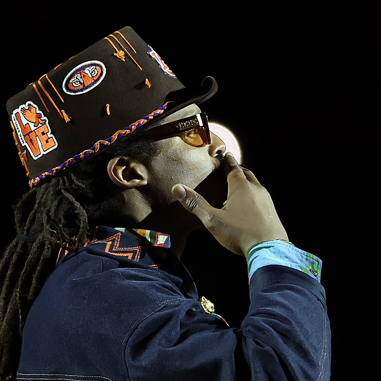 Cam Newton holds his hand over his mouth in quiet contemplation.