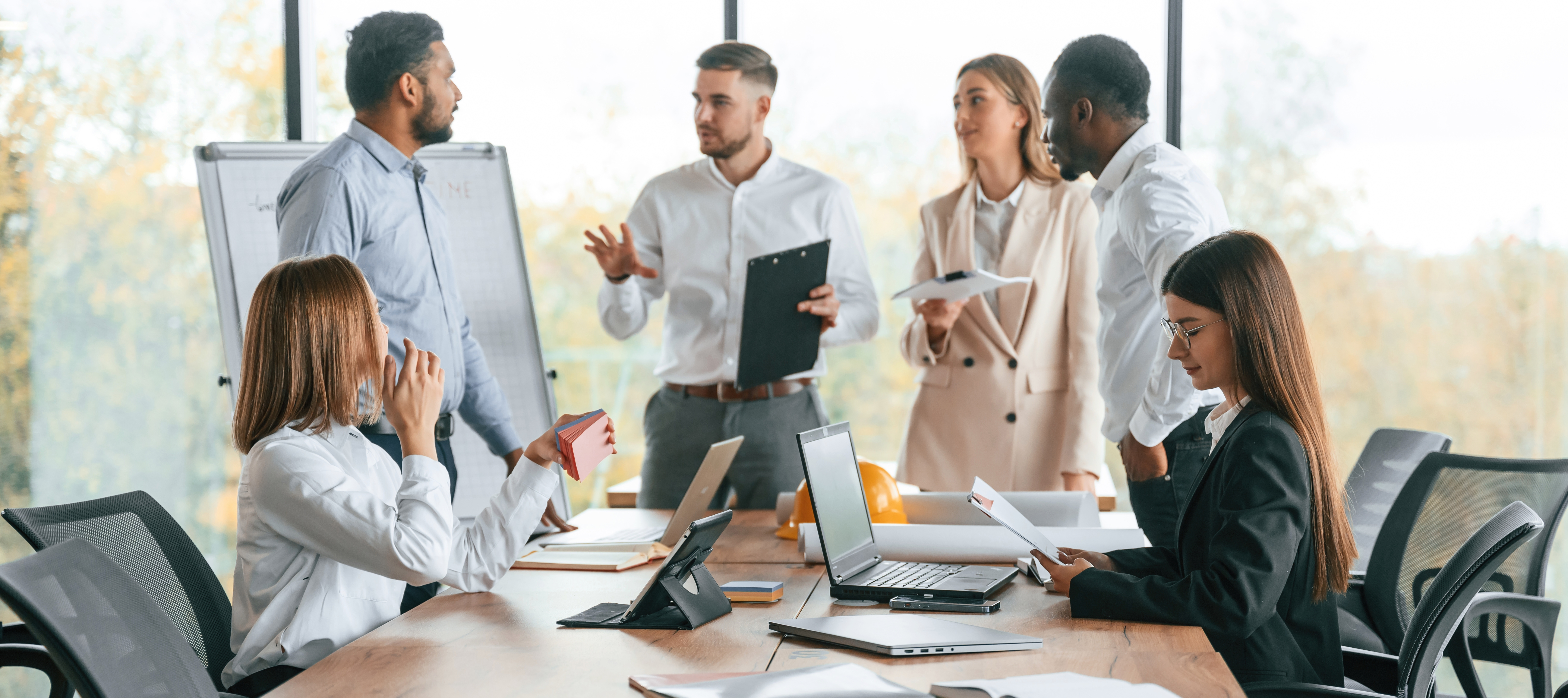 Coworkers gather together in a meeting room.