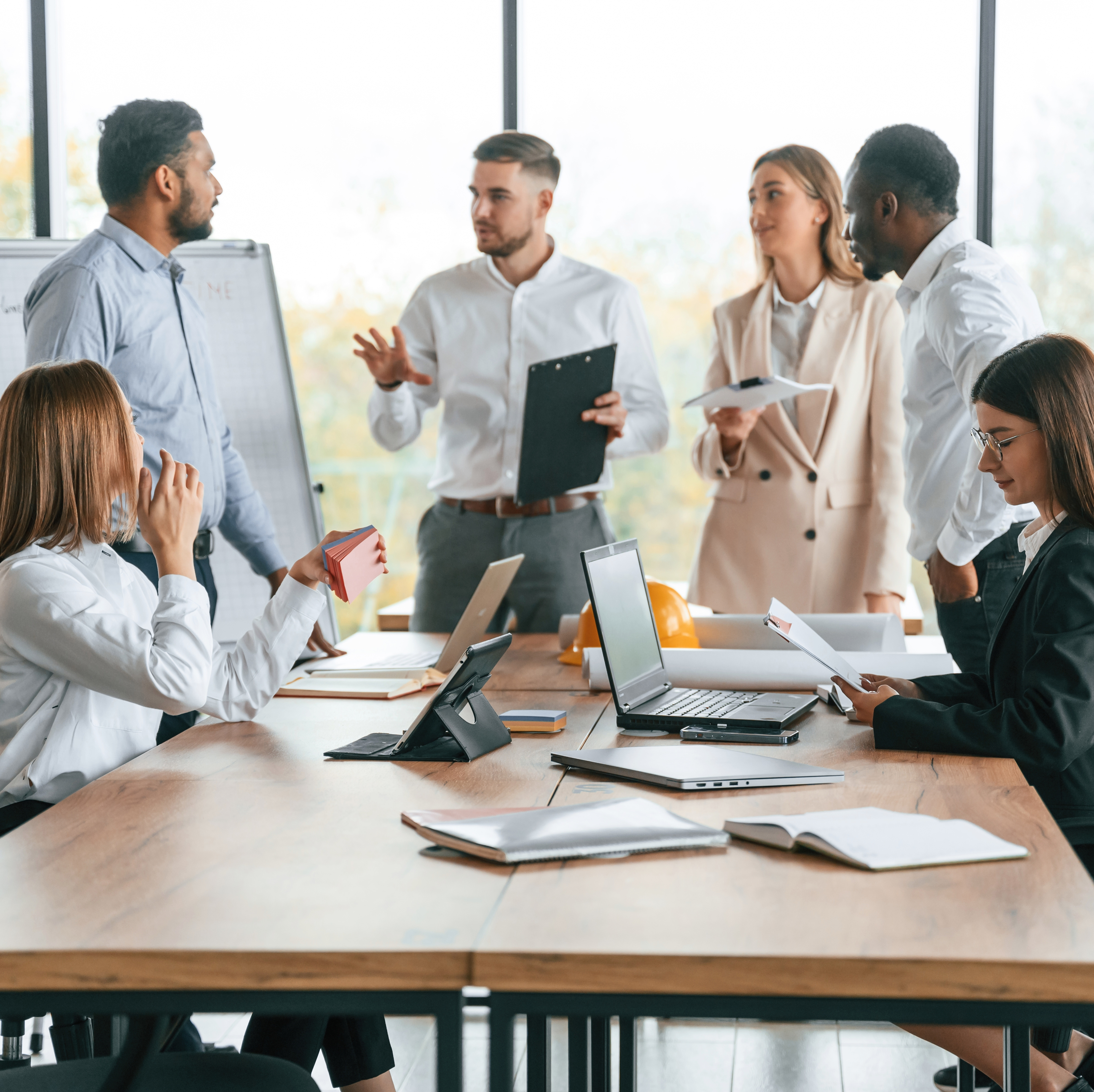 Coworkers gather together in a meeting room.