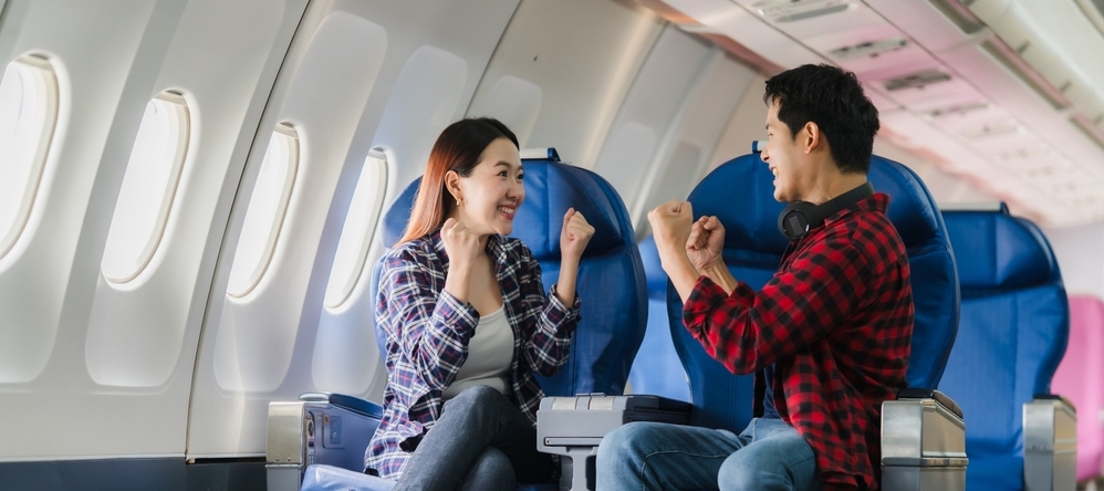Photo of two  happy passengers on an airplane