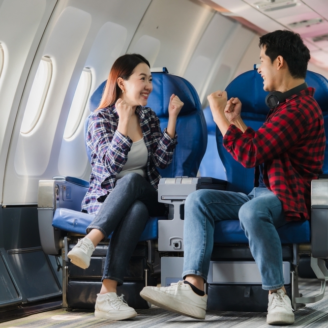 Photo of two  happy passengers on an airplane