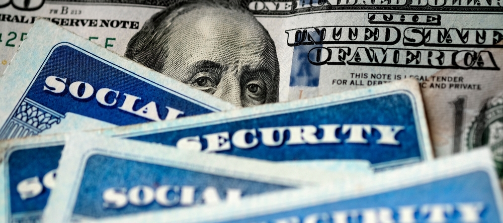 Several Social Security Cards on a one hundred dollar bill.