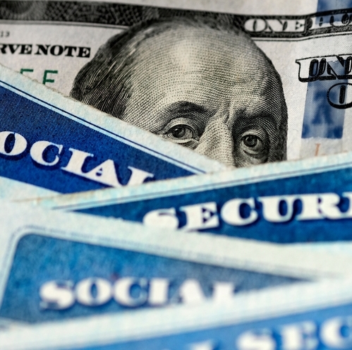 Several Social Security Cards on a one hundred dollar bill.