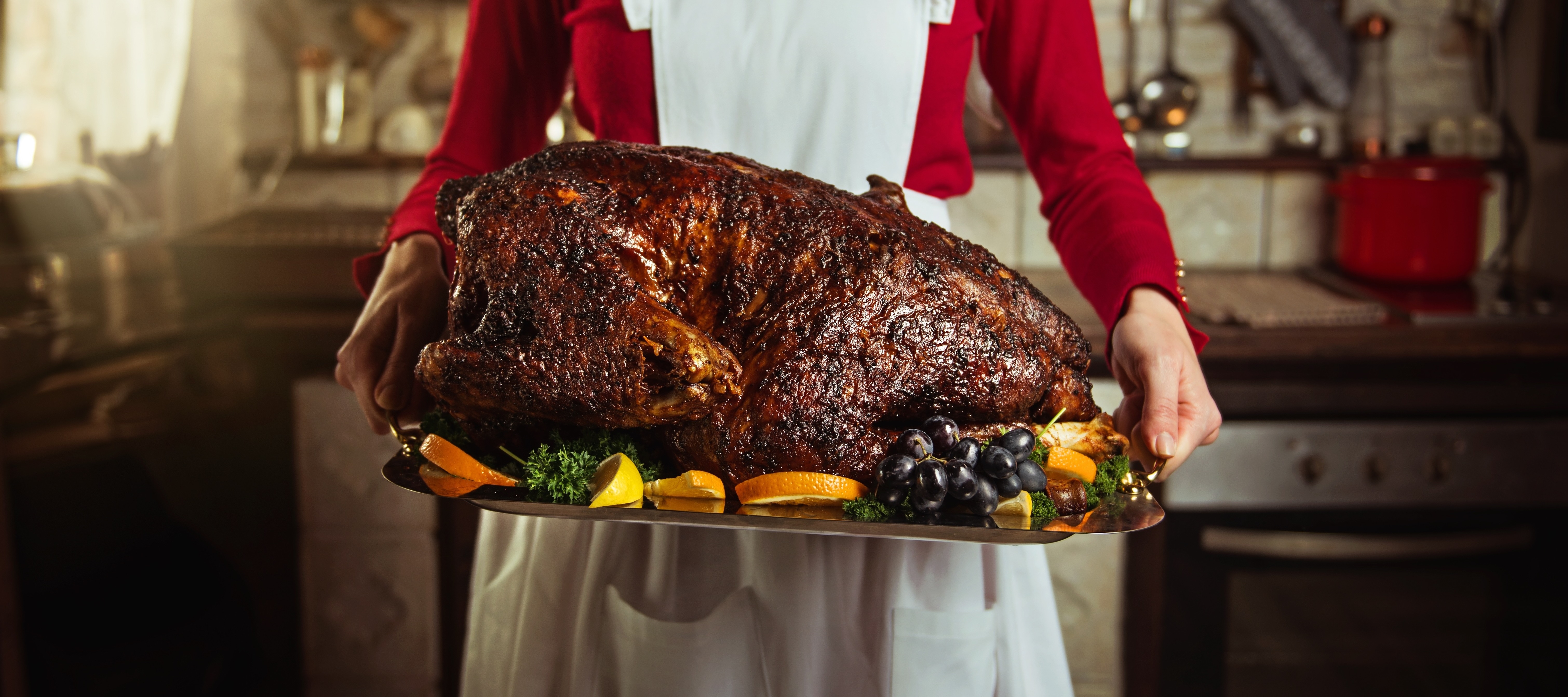 A trad wife holding a traditional turkey dinner roast.