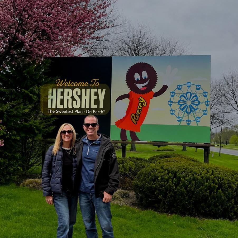 Lisa and Matt stand in front of sign in Hershey Pennsylvania.