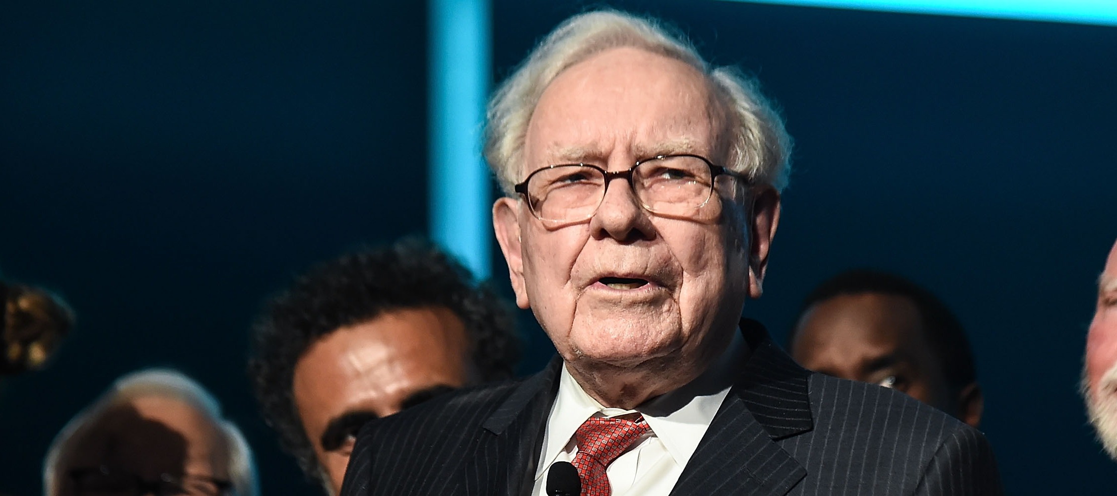 Warren Buffett, in a dark pin-stripped suit, looks out at the photographer cautiously.