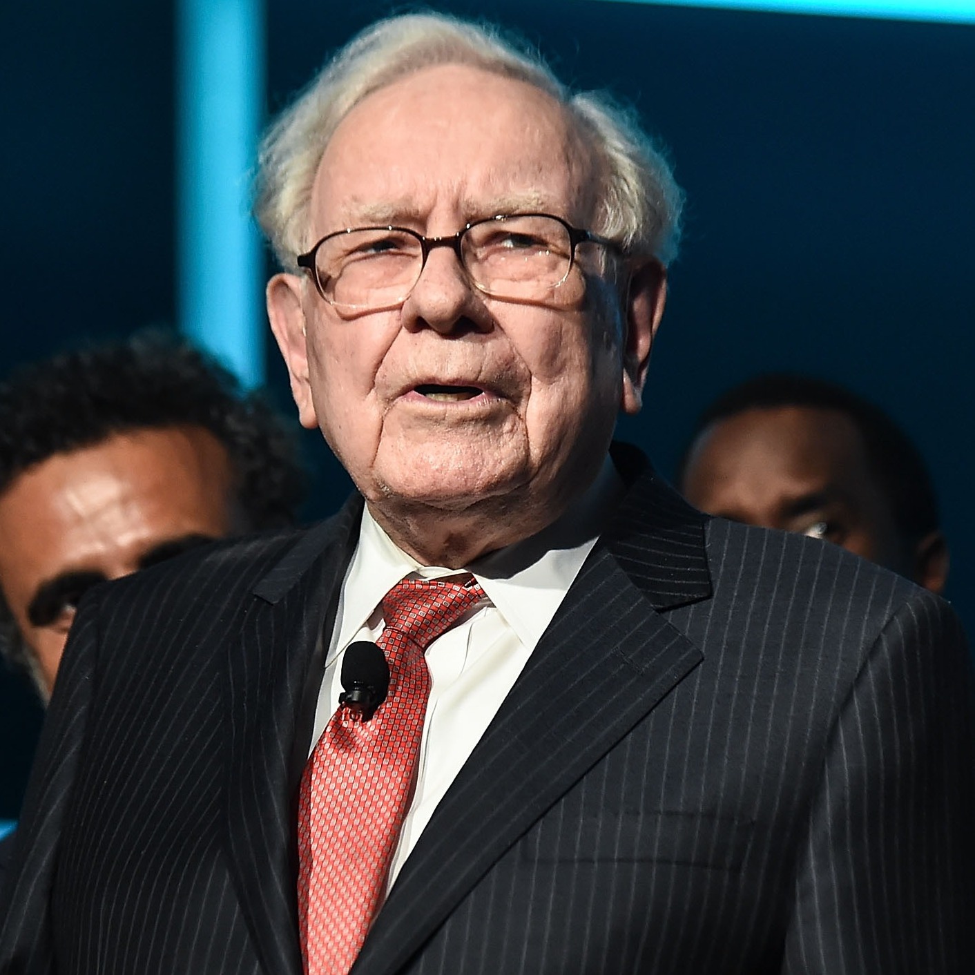 Warren Buffett, in a dark pin-stripped suit, looks out at the photographer cautiously.