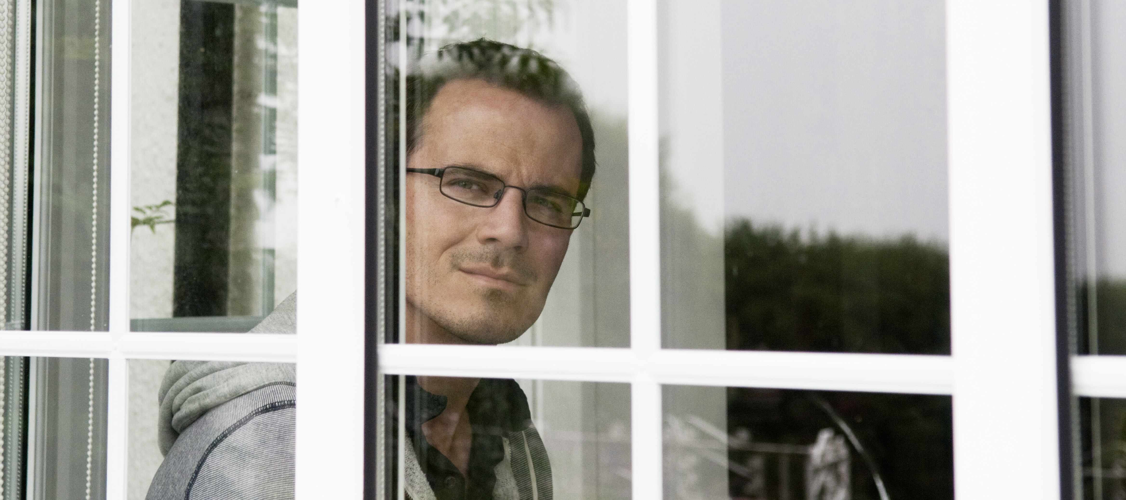 Man thoughtfully looking out the window