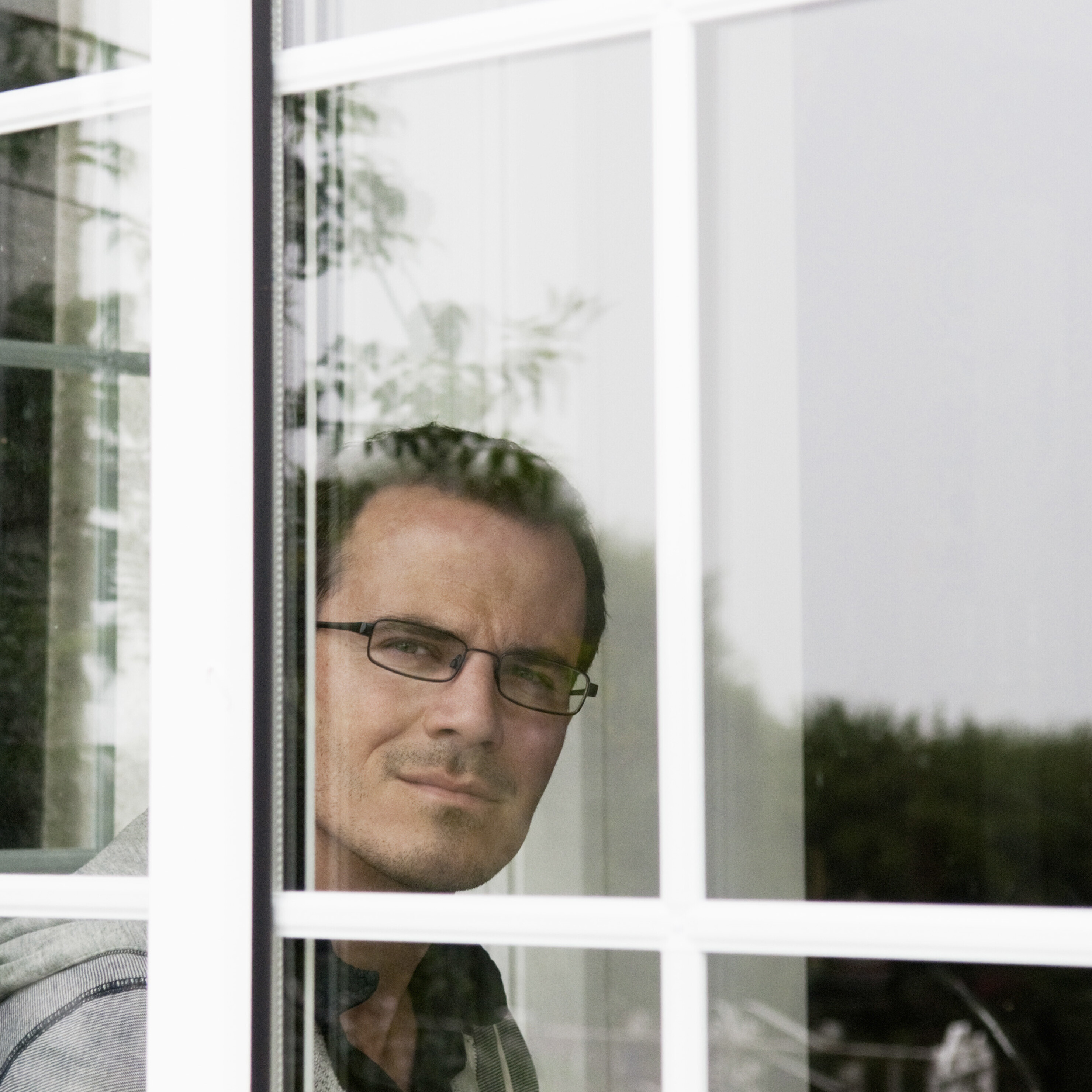 Man thoughtfully looking out the window