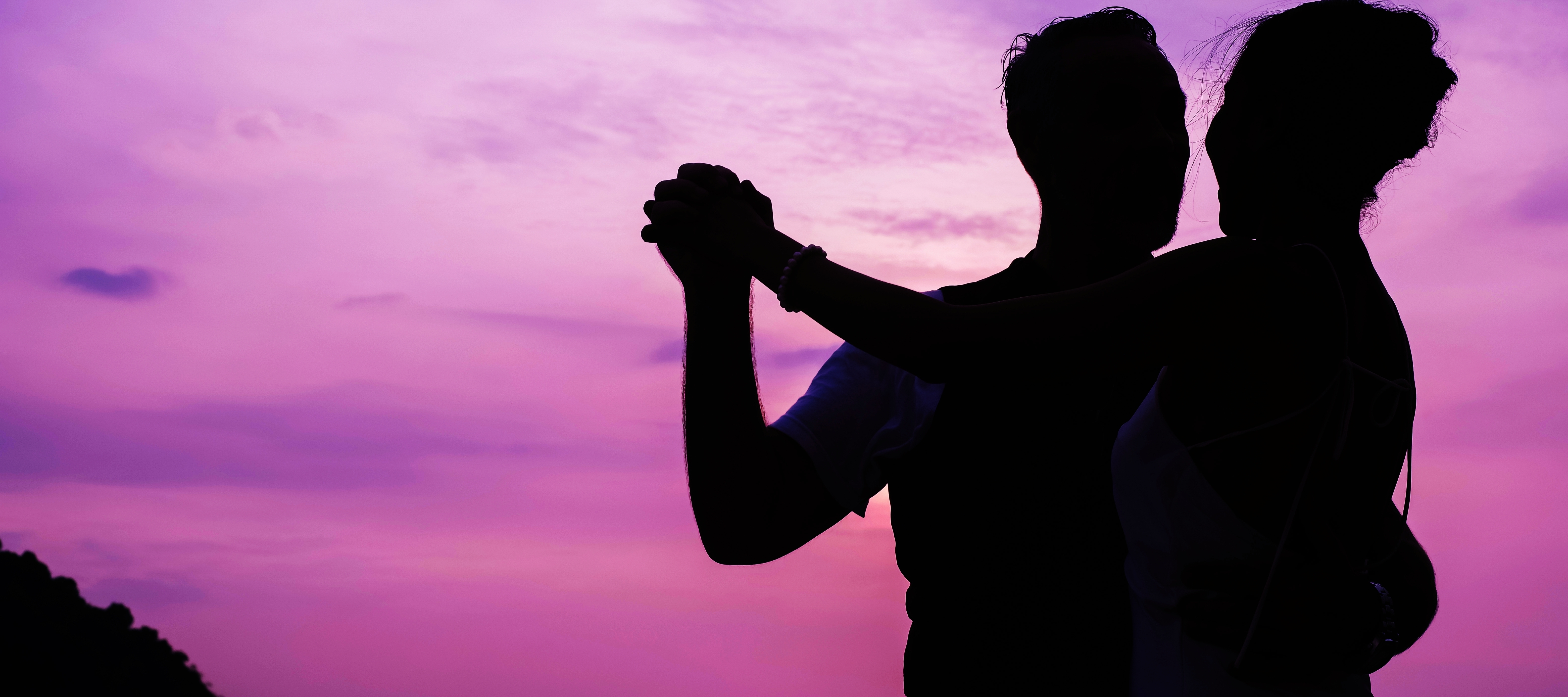 The silhouette of a couple dancing on the beach at night.